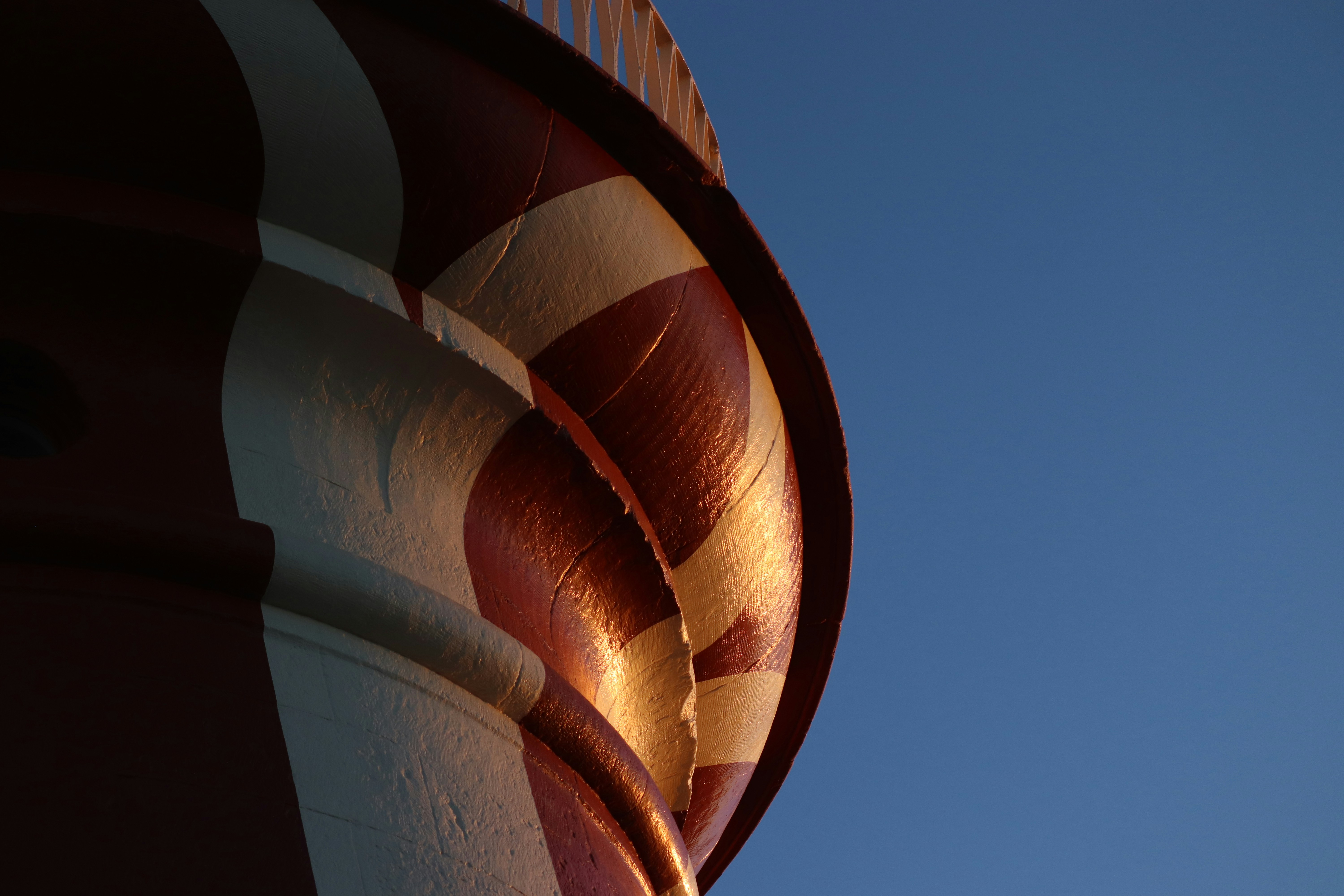Teil eines gestreiften Turms vor blauem Himmel.