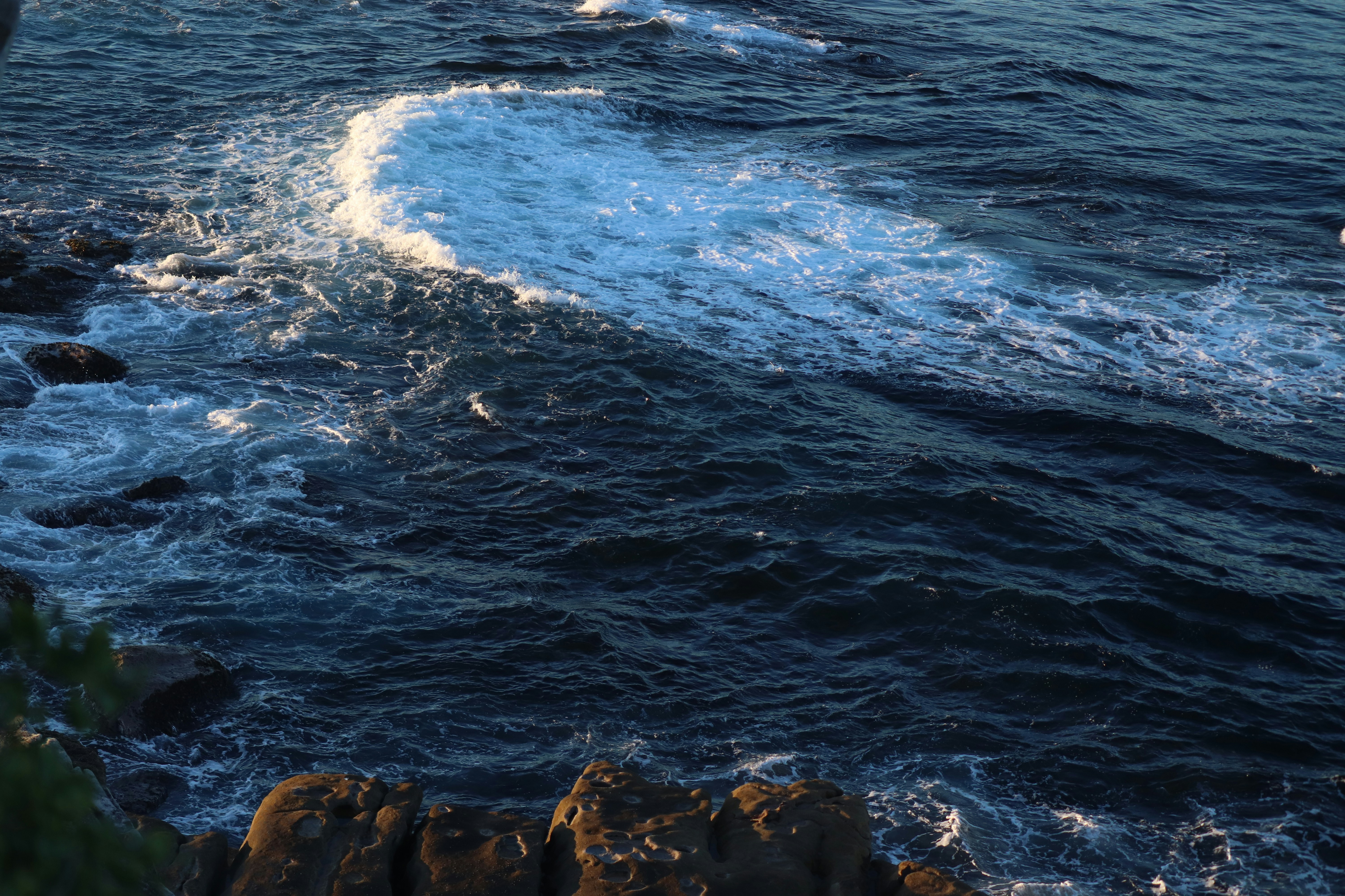 Wellen schlagen gegen die felsige Küste.