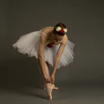A ballerina ties her pointe shoe
