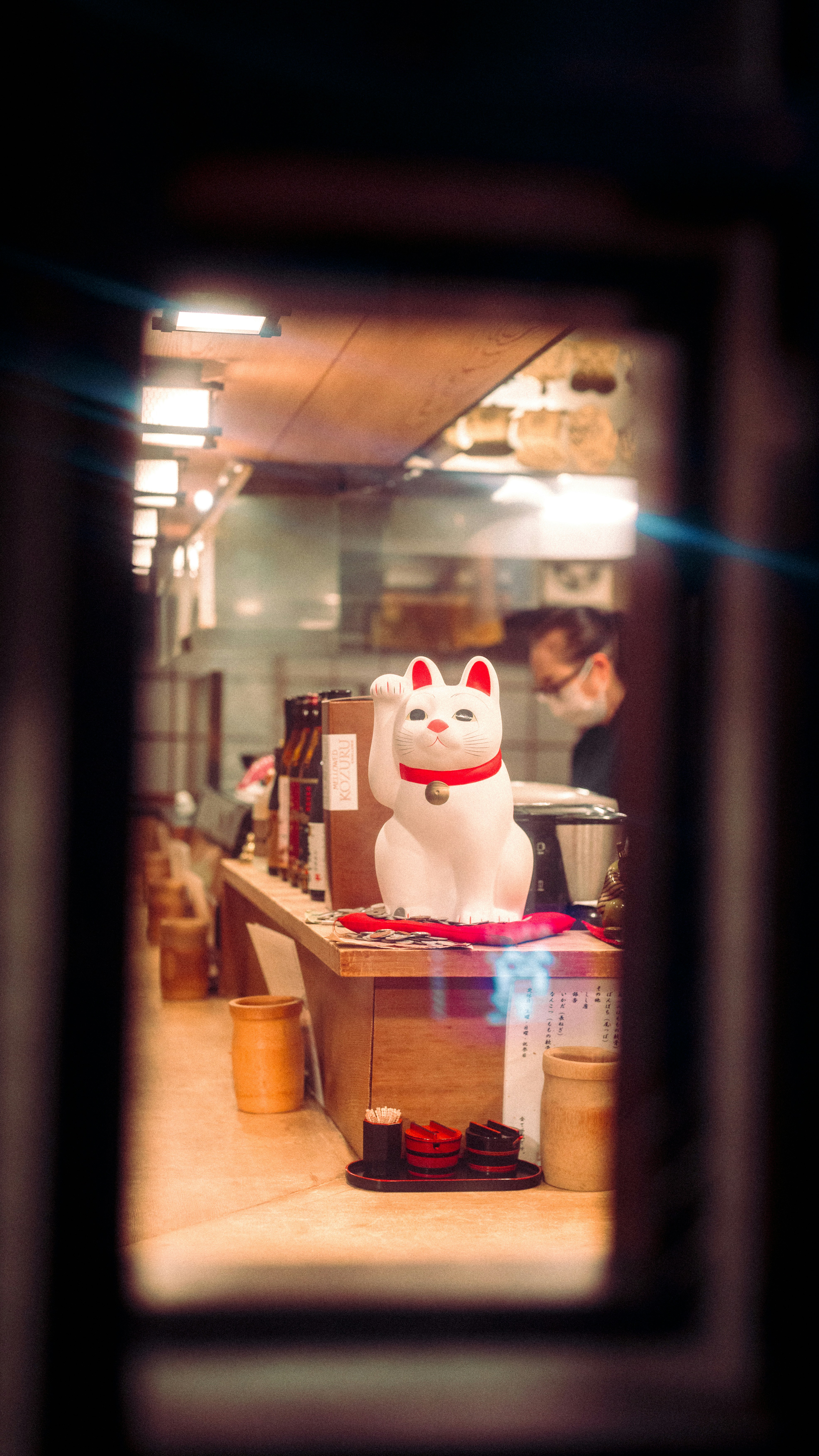 A lucky cat figurine welcomes customers in a restaurant.