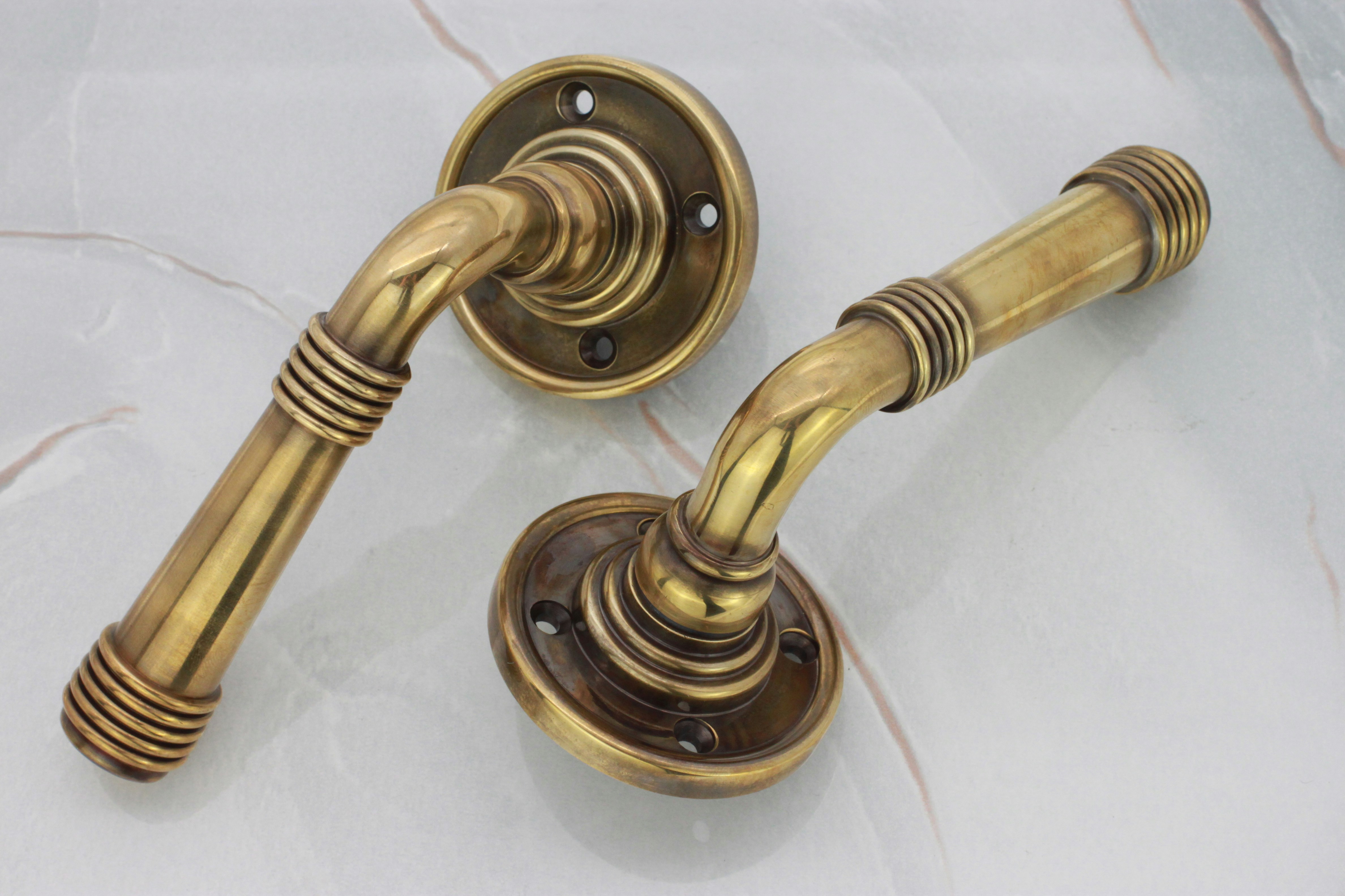 Two antique brass door handles are shown.