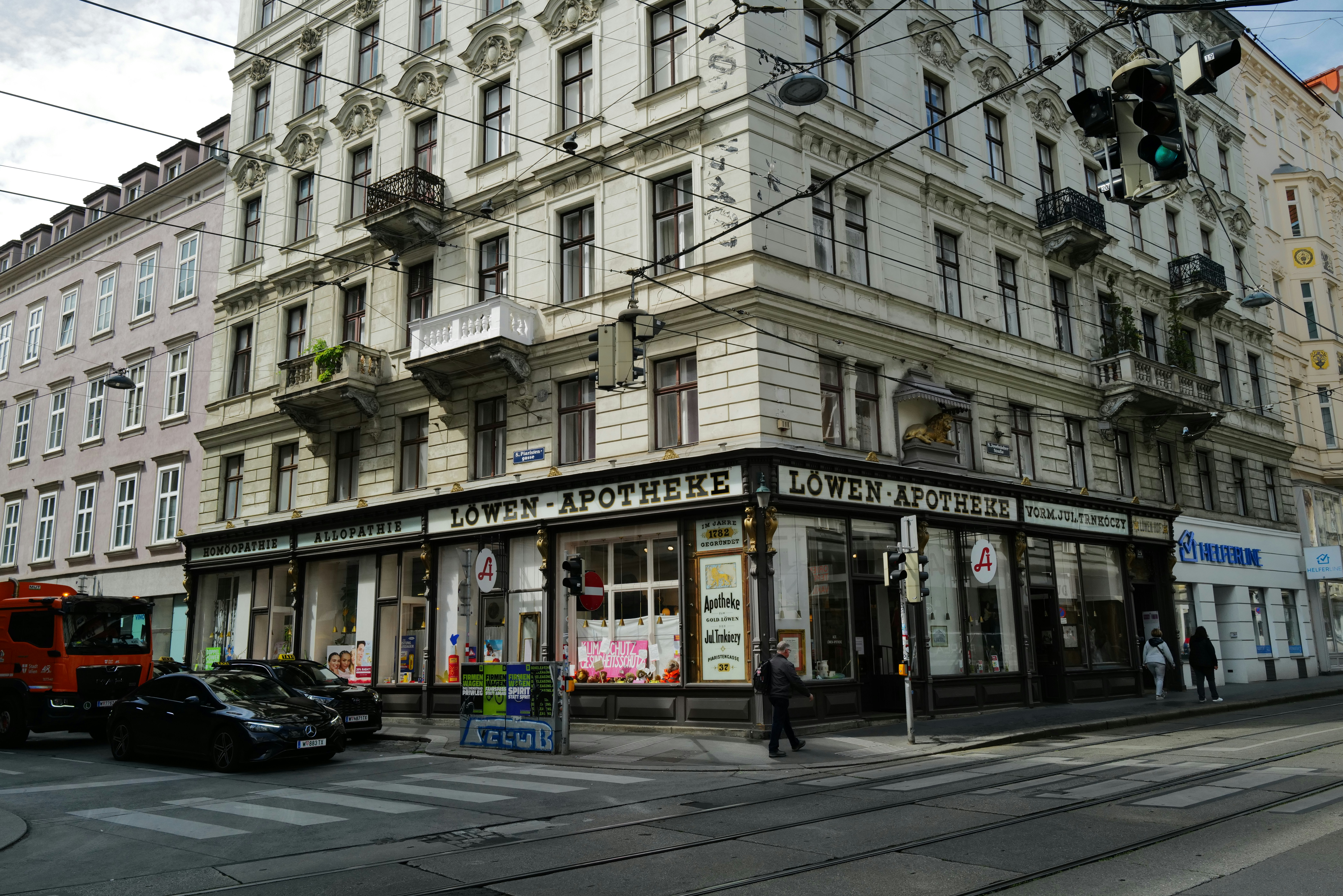 Um prédio de esquina possui uma farmácia de fachada.