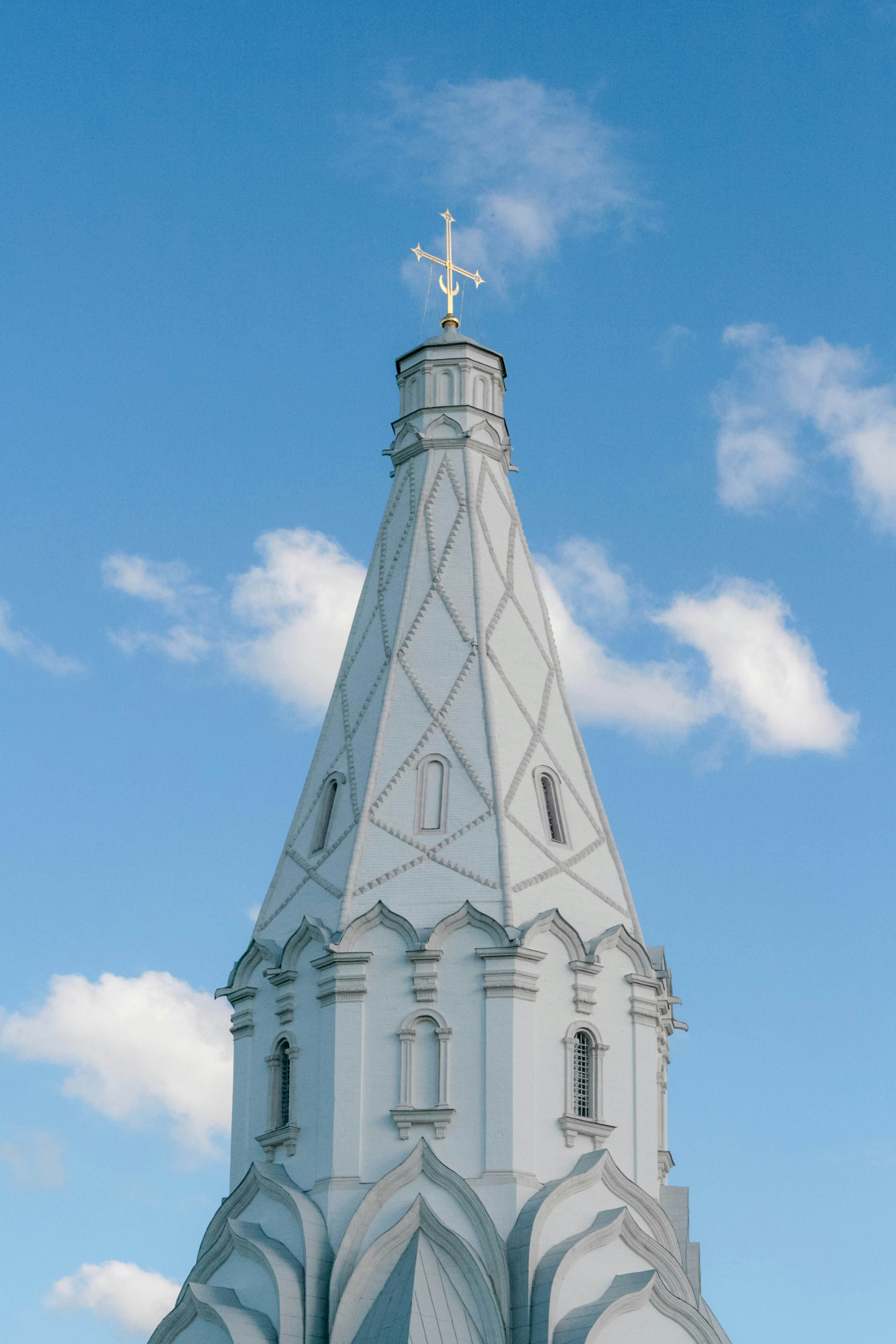 A church steeple against a blue, cloudy sky.