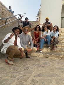 A group of friends poses together on some steps.