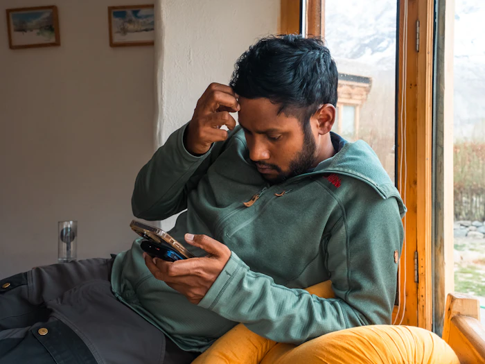 Persona real mirando su celular con expresión de preocupación por una alerta
