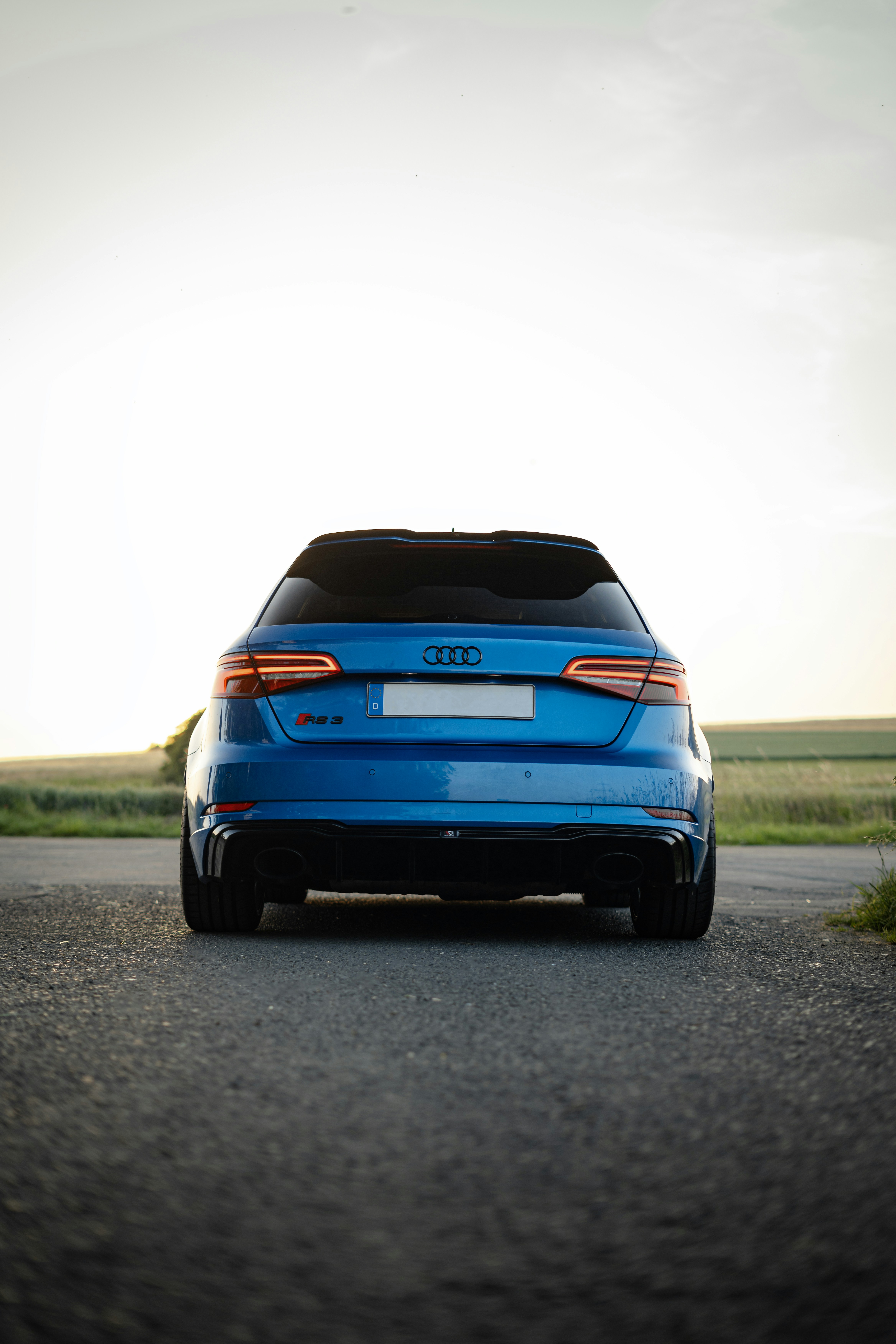 A blue audi rs3 is parked on a road.