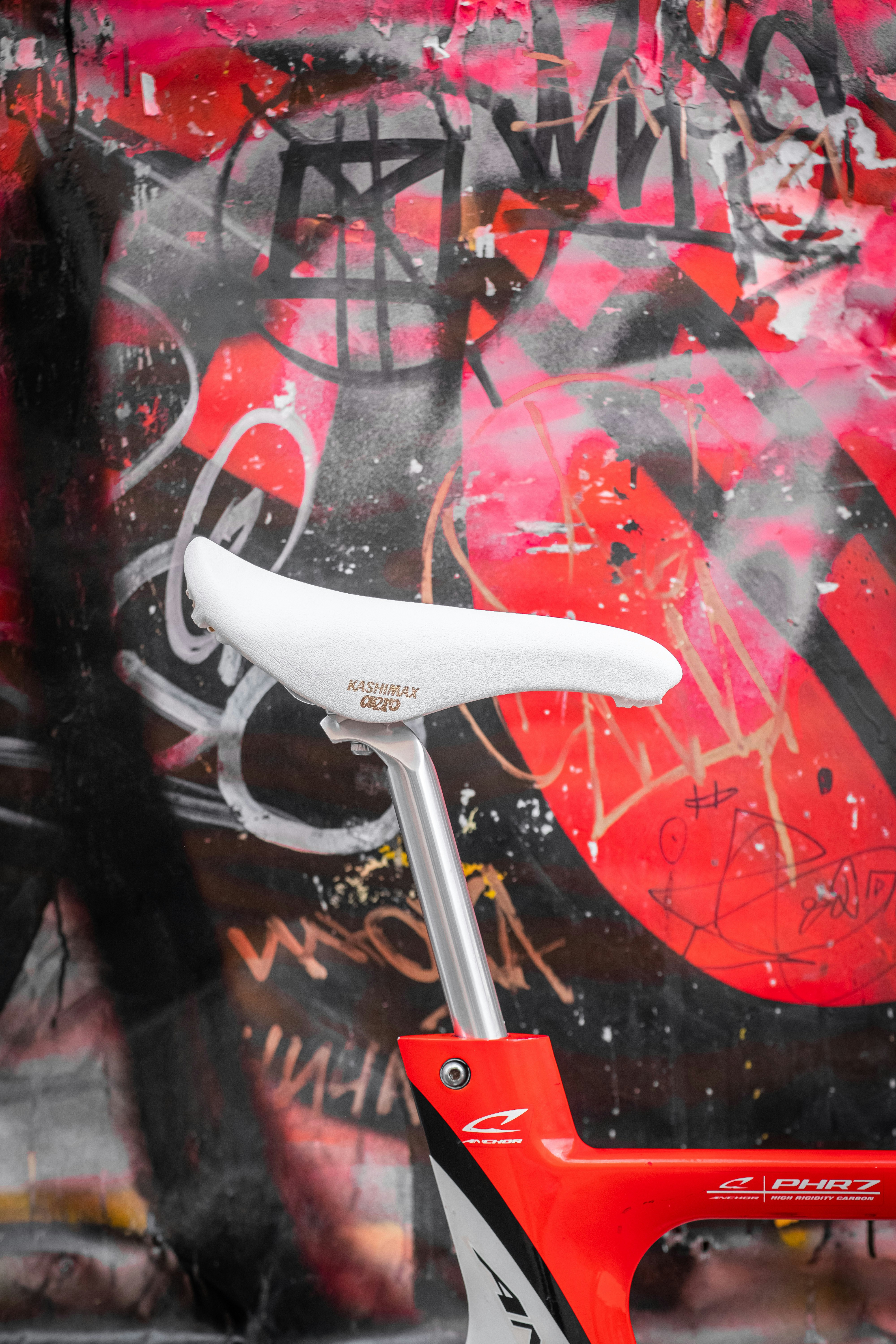 Bike seat against a graffiti-covered background.