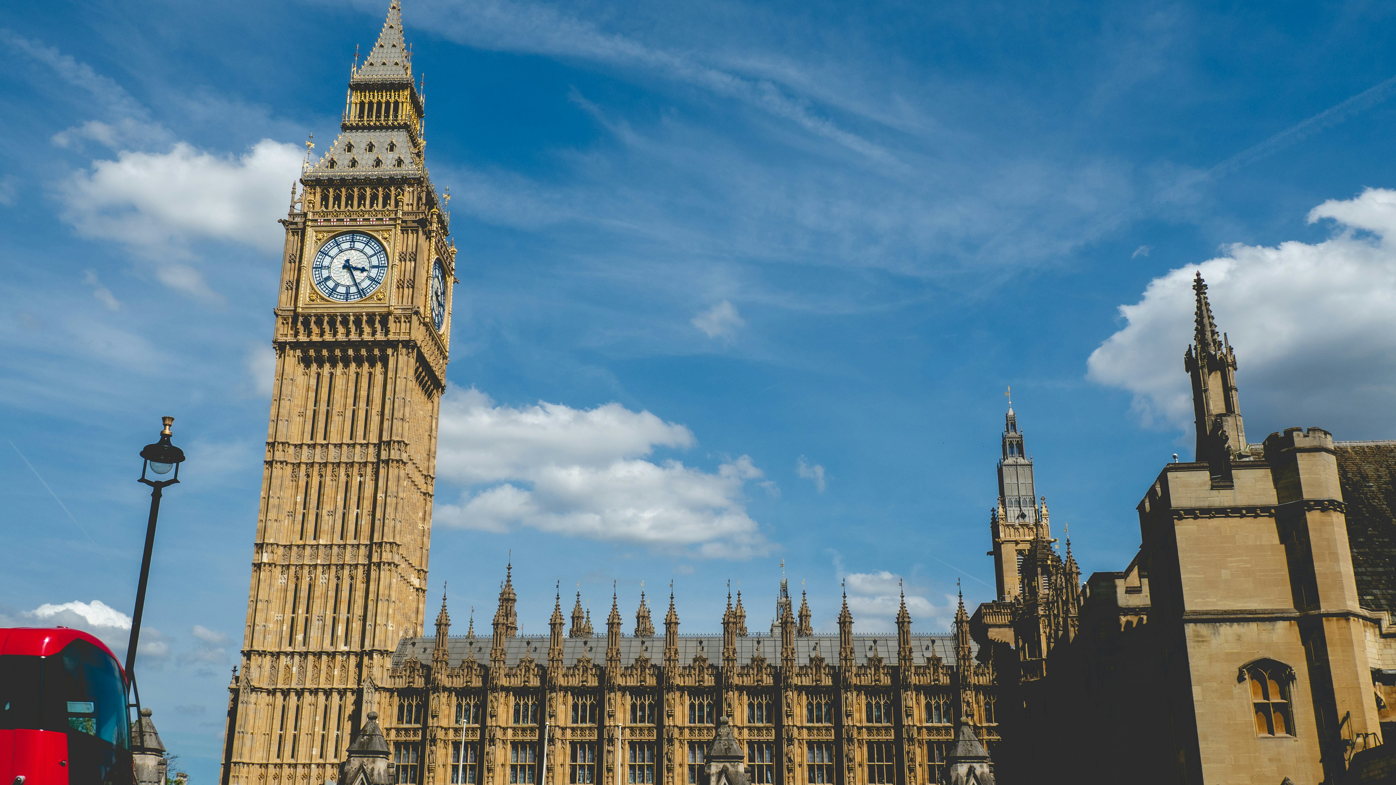 Big ben clock tower stands tall against a blue sky.