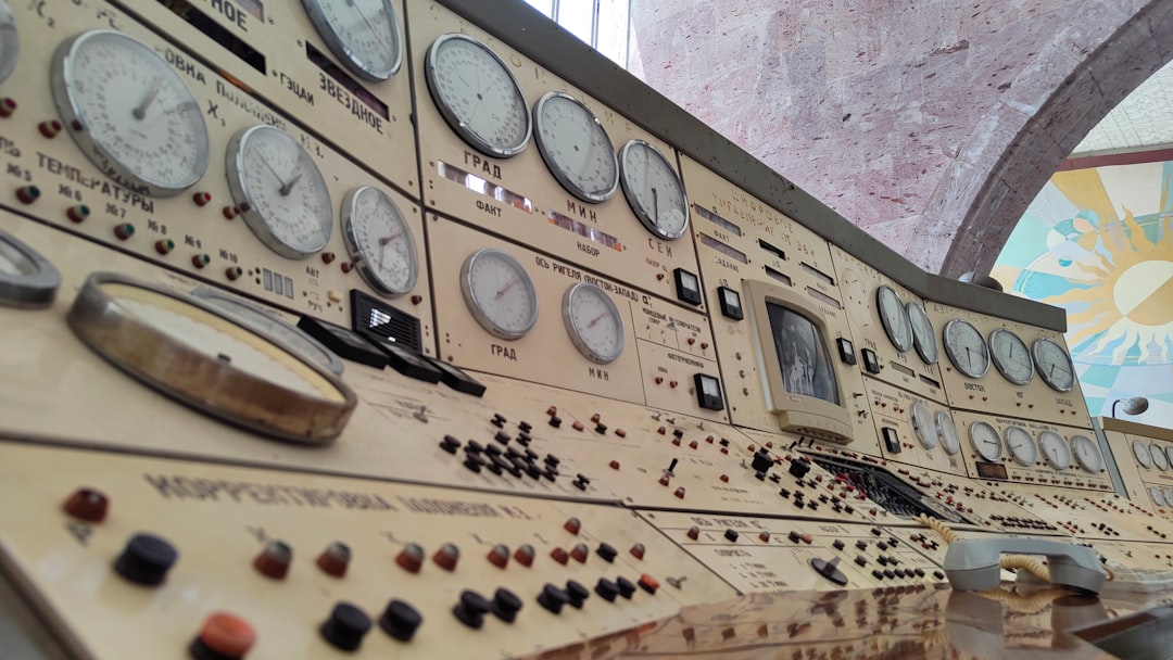 Vintage control panel is filled with gauges and buttons.,