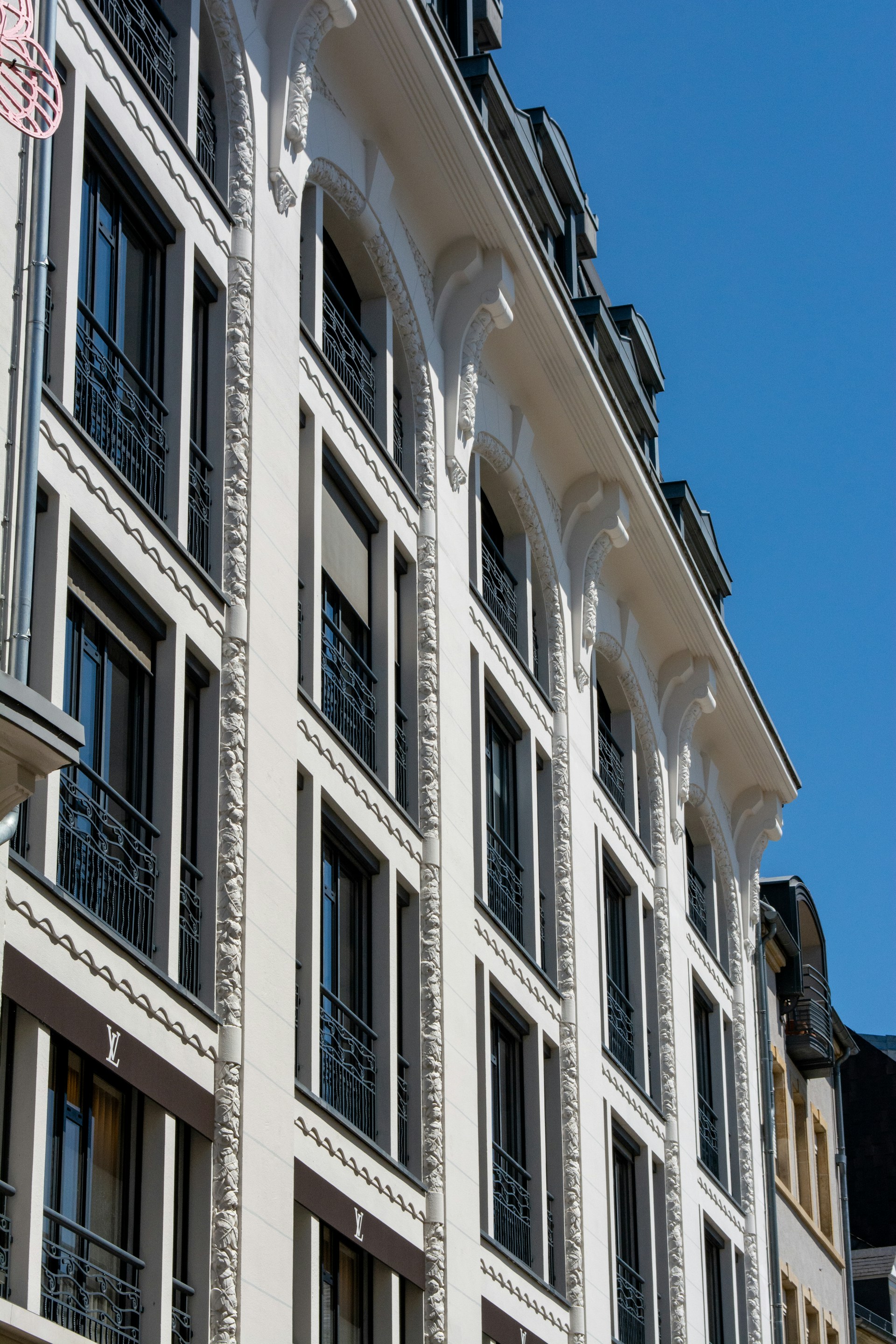 Elegant building with many windows against a blue sky.