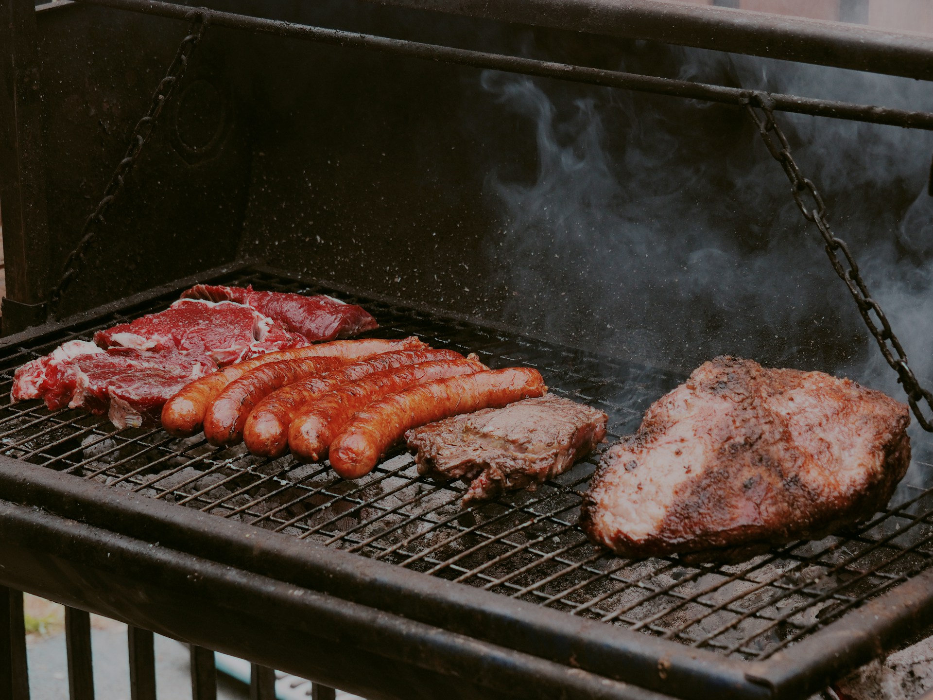 Meat is being grilled on a barbeque.