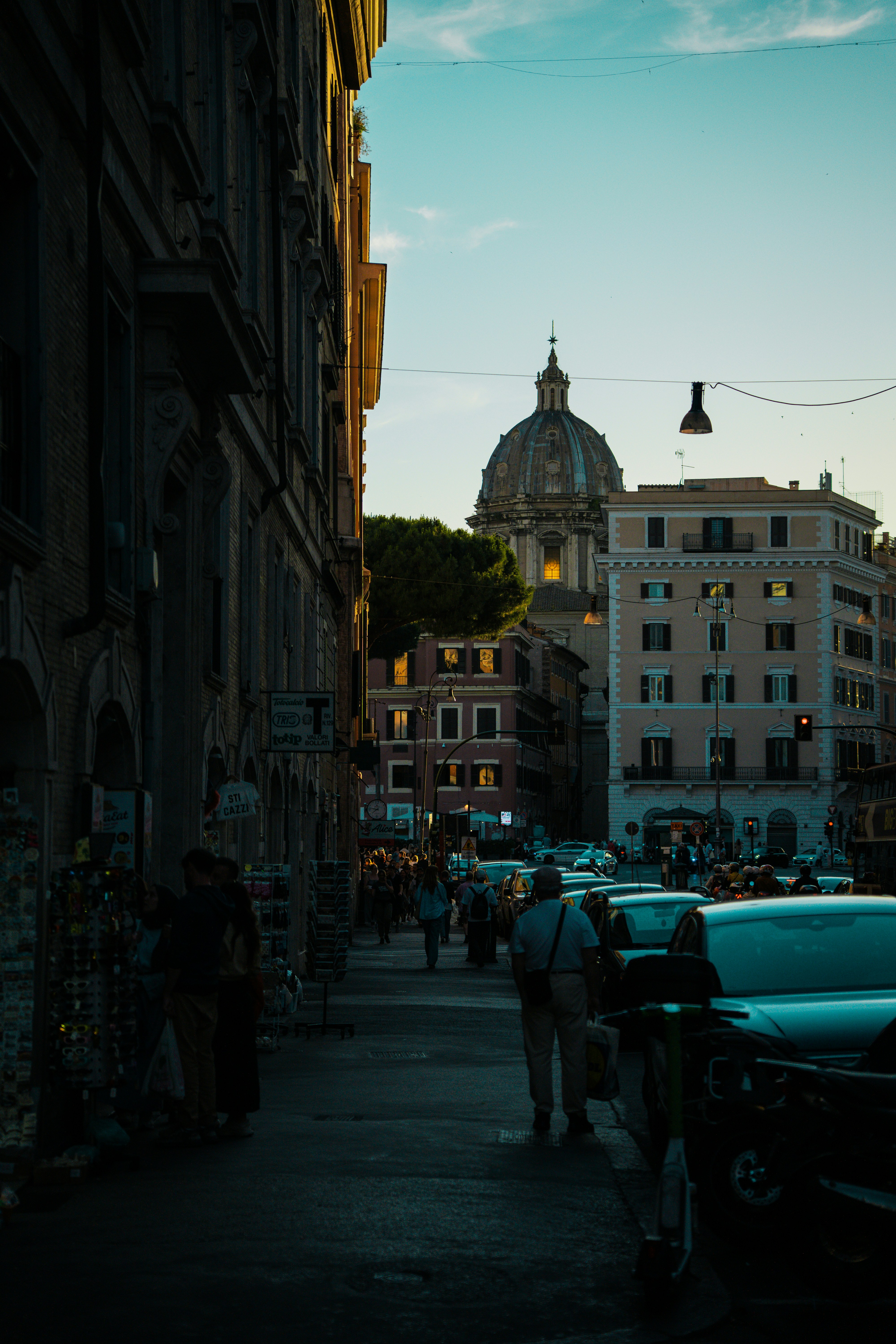 La puesta de sol ilumina una calle italiana con una cúpula.