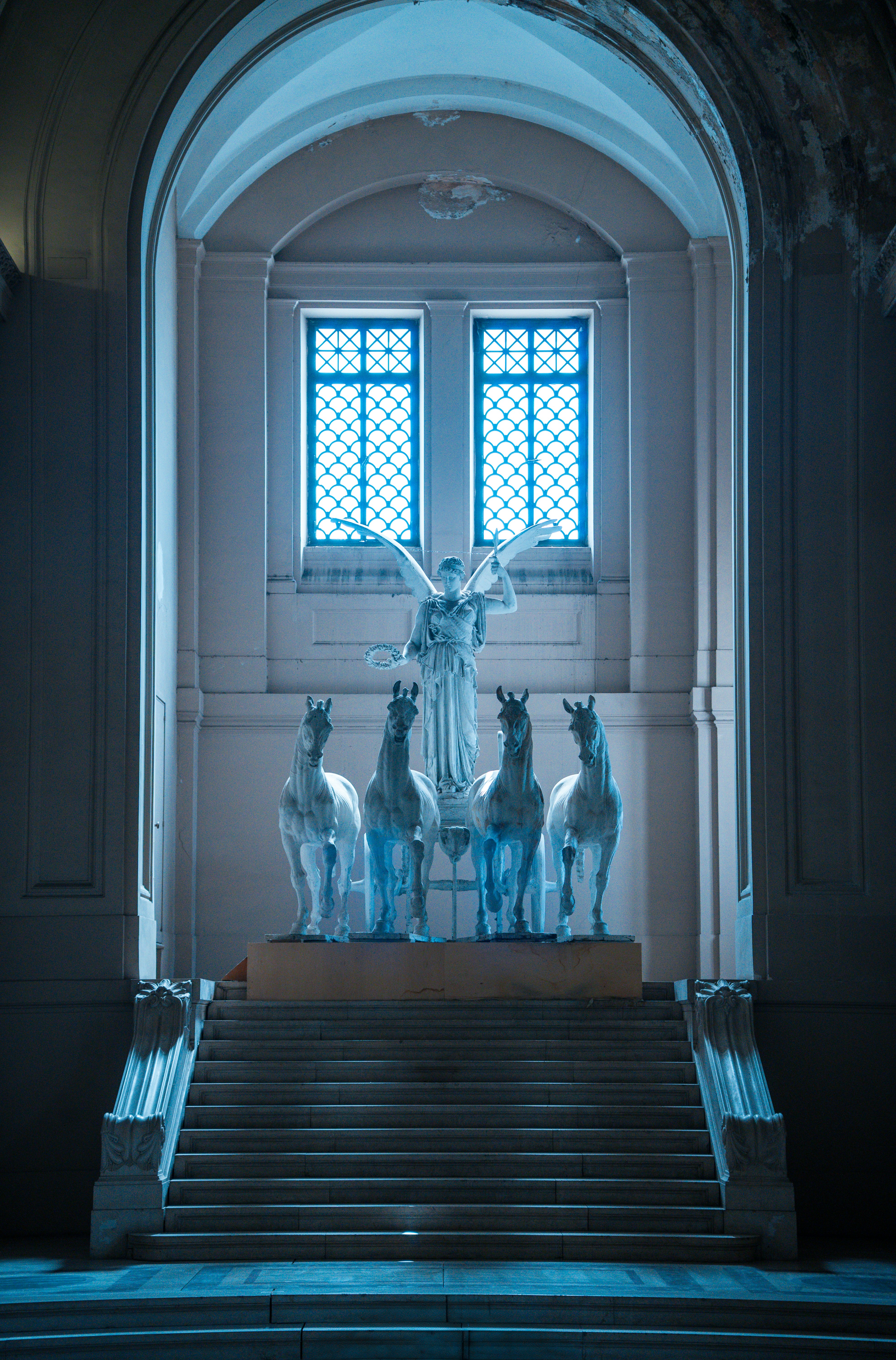 Una estatua de ángel se encuentra sobre las estatuas de los caballos.