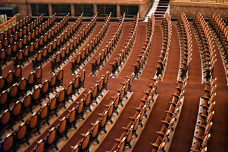 Rows of empty chairs fill a large auditorium.