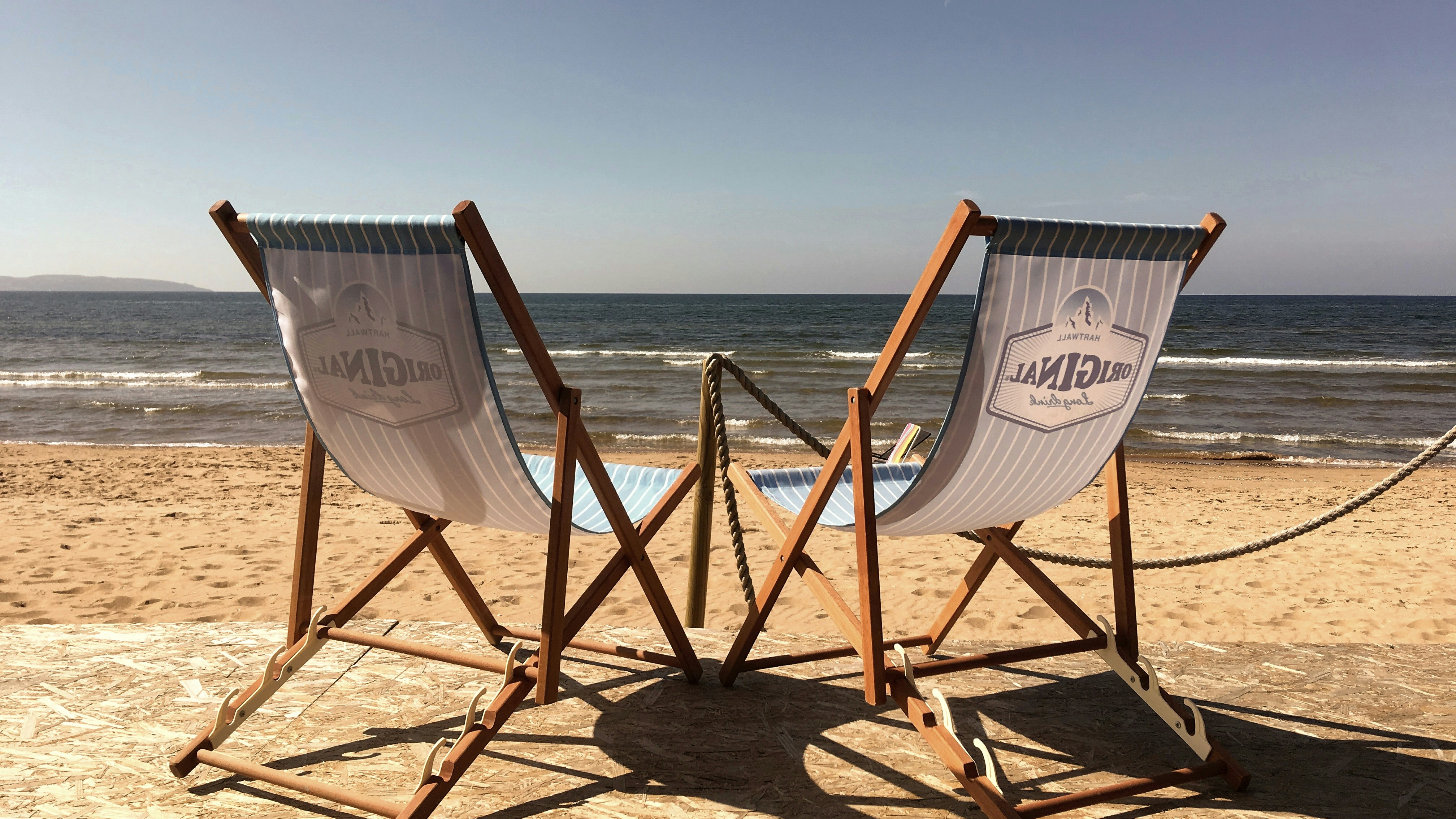 Beach chairs face the ocean on a sunny day.
