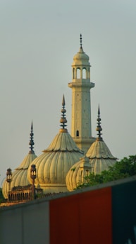 A mosque's domes and minaret against a clear sky.