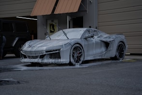 A corvette is being washed with foamy soap.