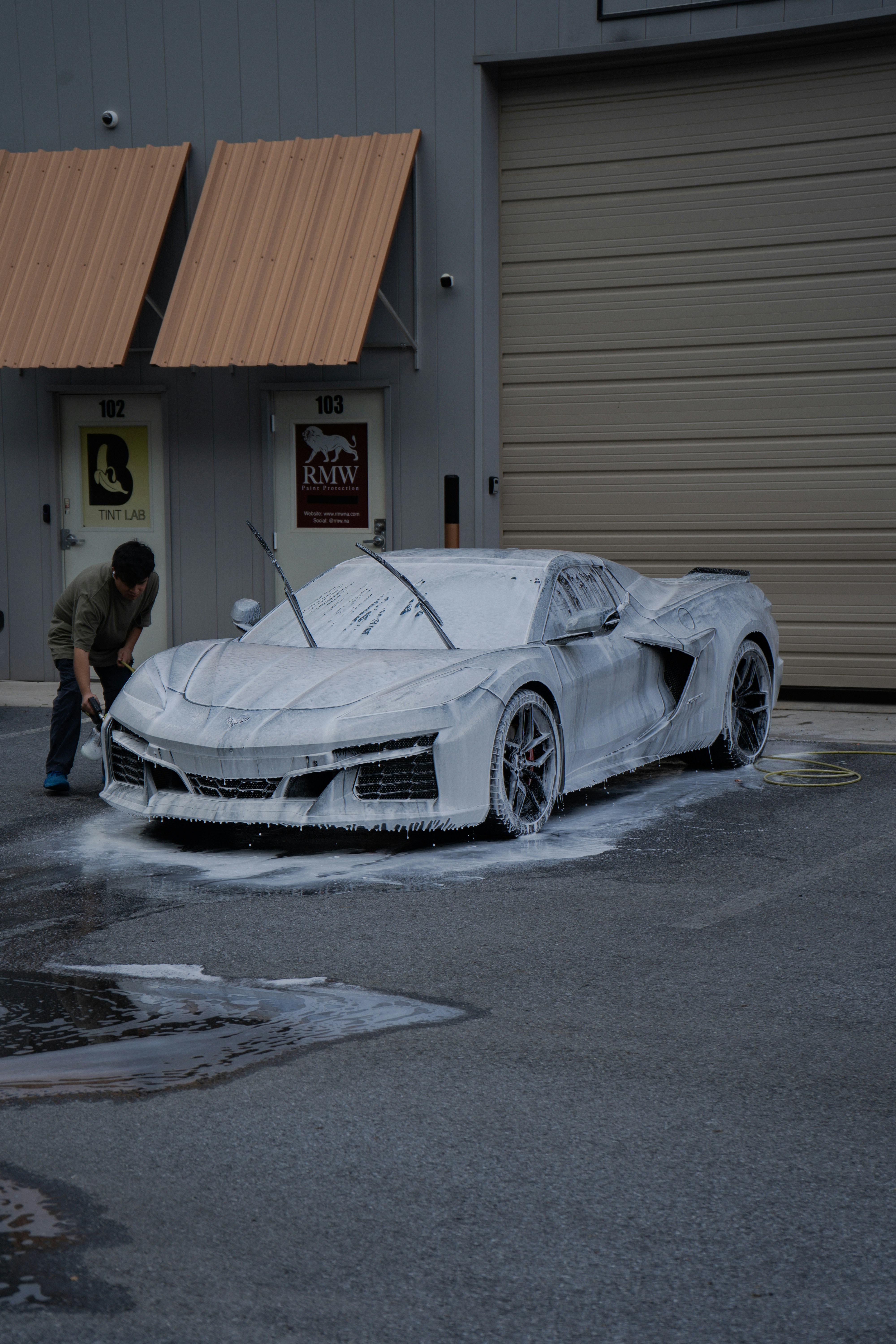 A car being covered in thick cleaning foam during a professional wash