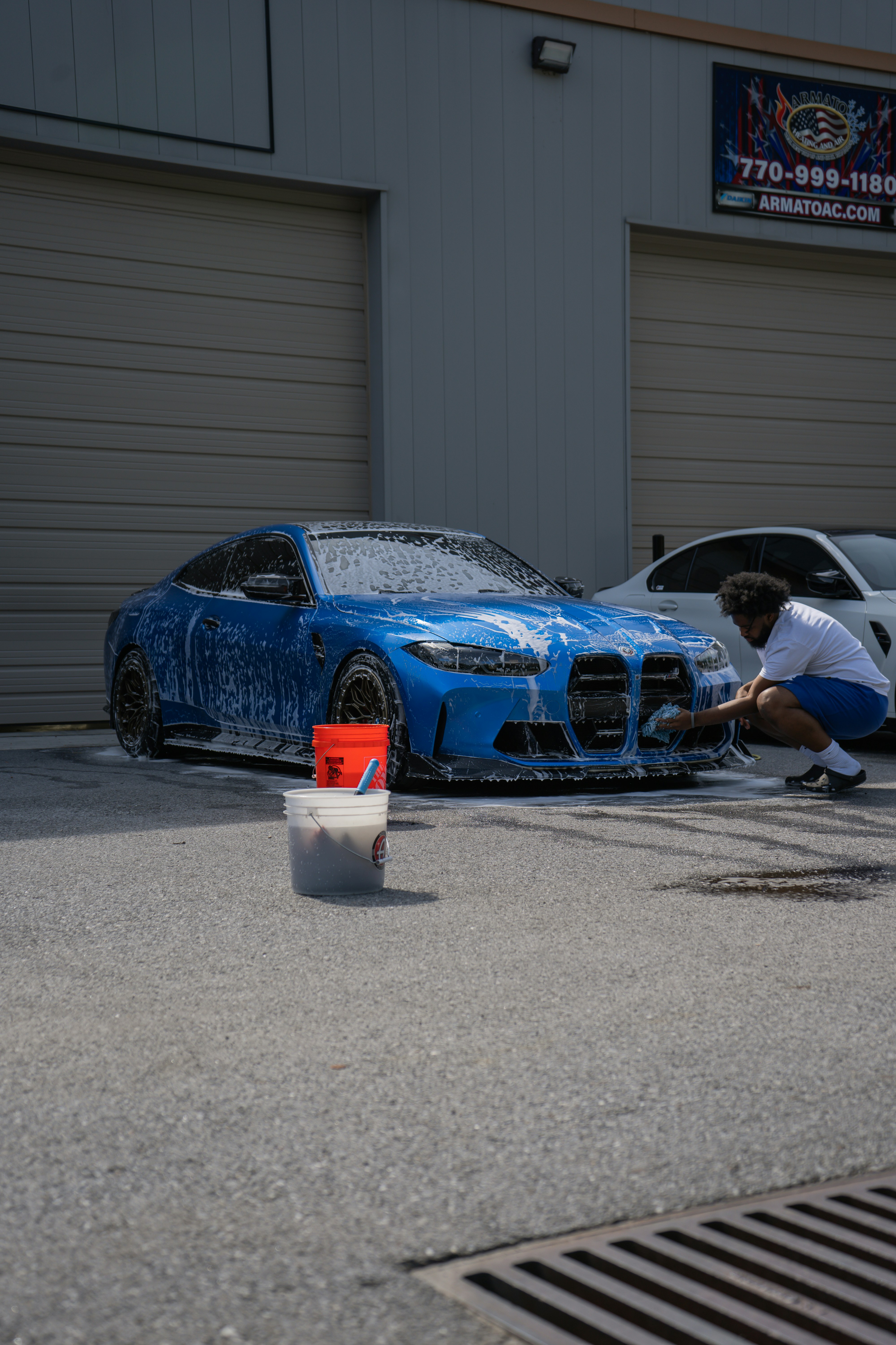 Person washing a blue sports car