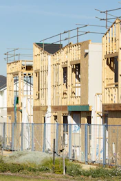 Houses are under construction, with exposed framing.