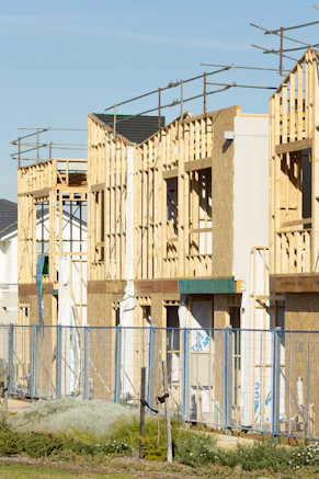 Houses are under construction, with exposed framing