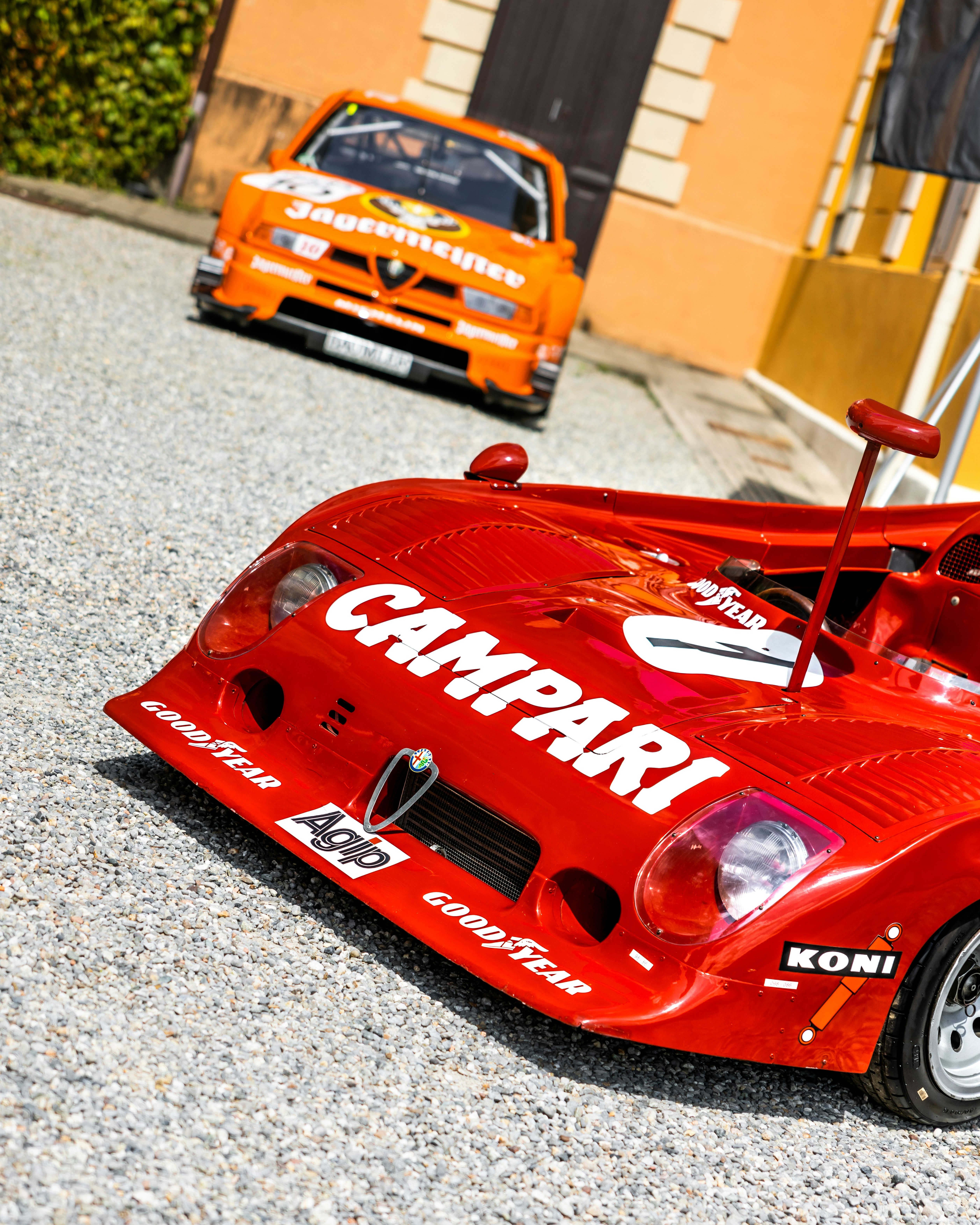 Two classic alfa romeo race cars in the image.