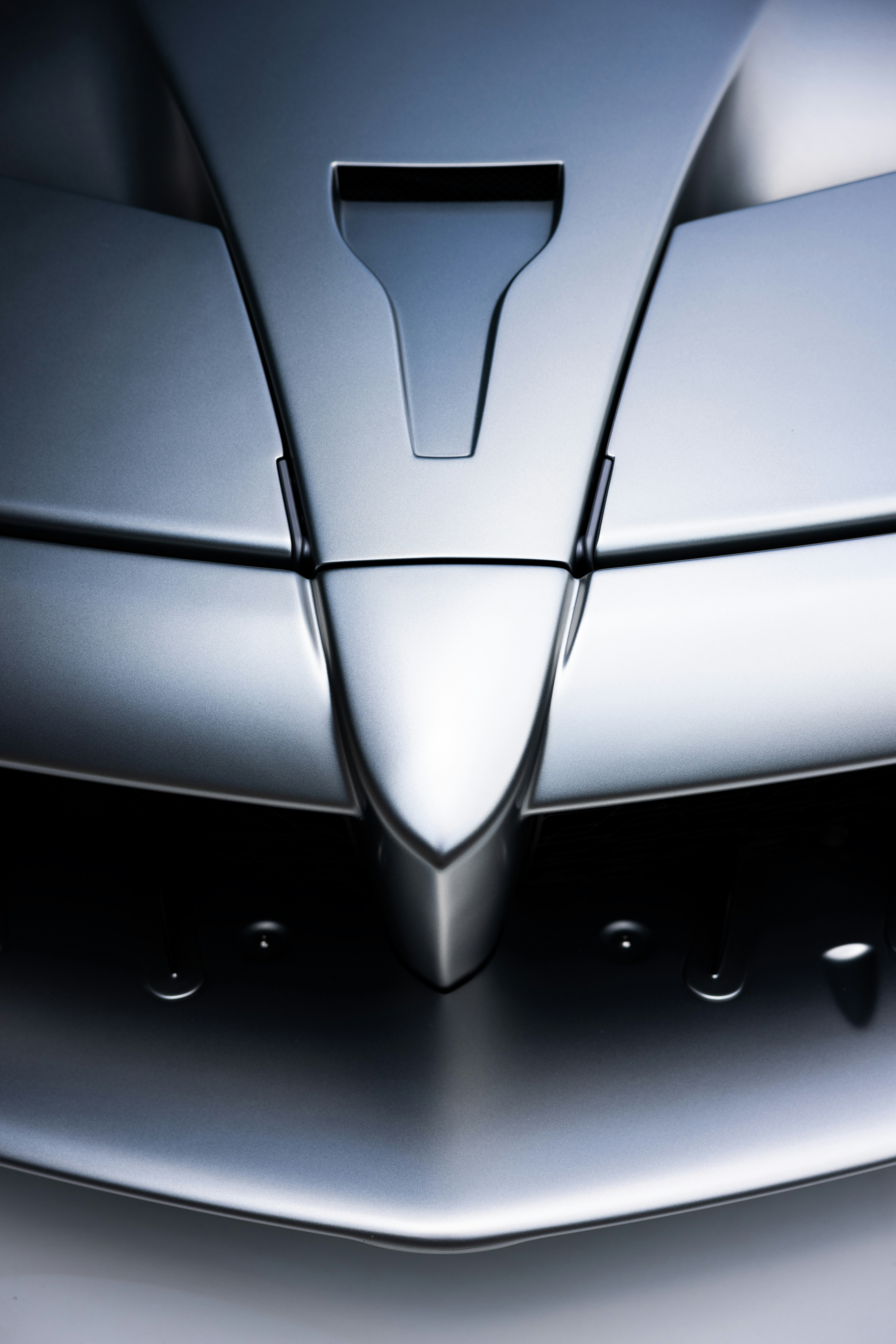 A close-up shows the sleek front of a car.