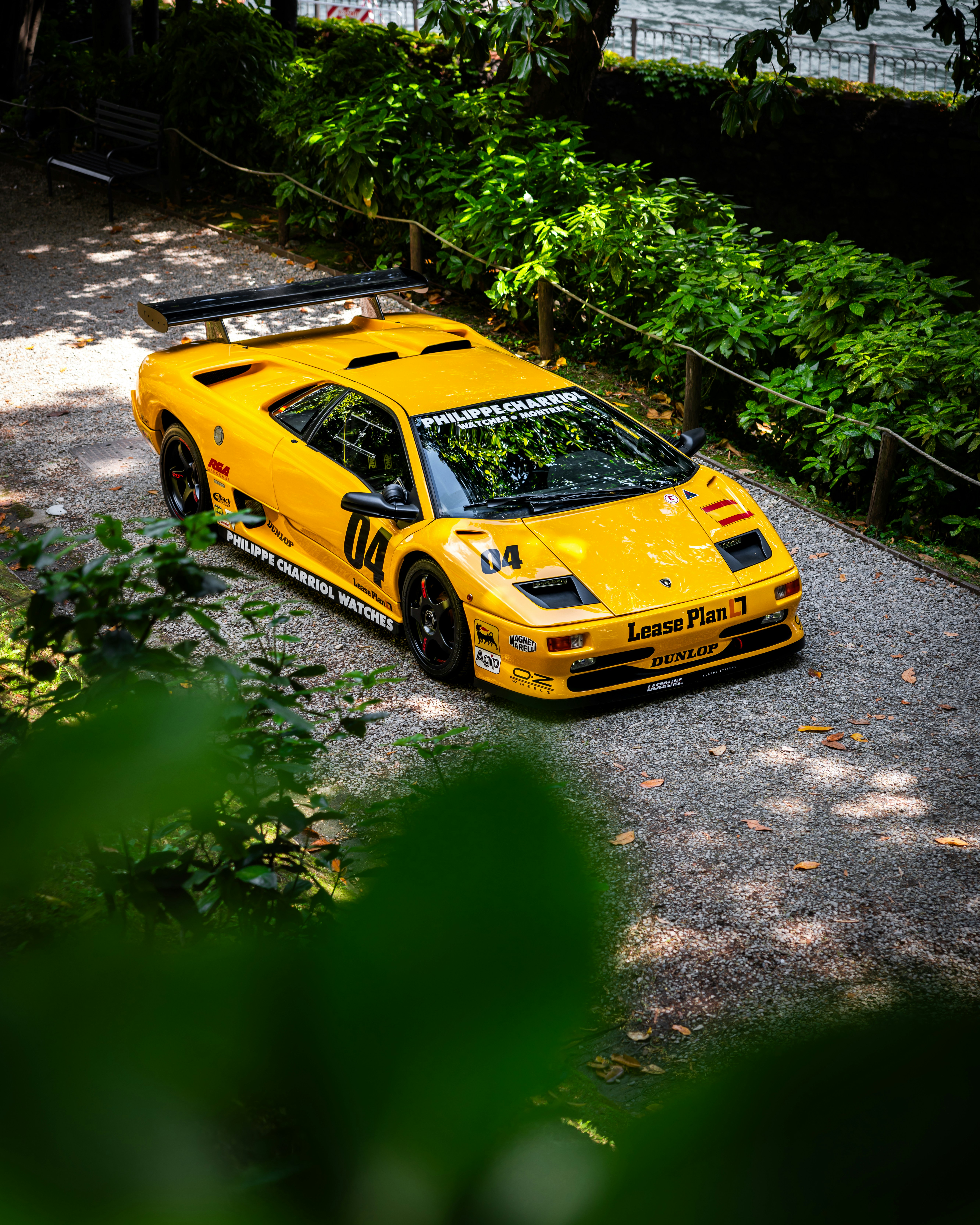 Yellow lamborghini diablo is parked on a pathway.