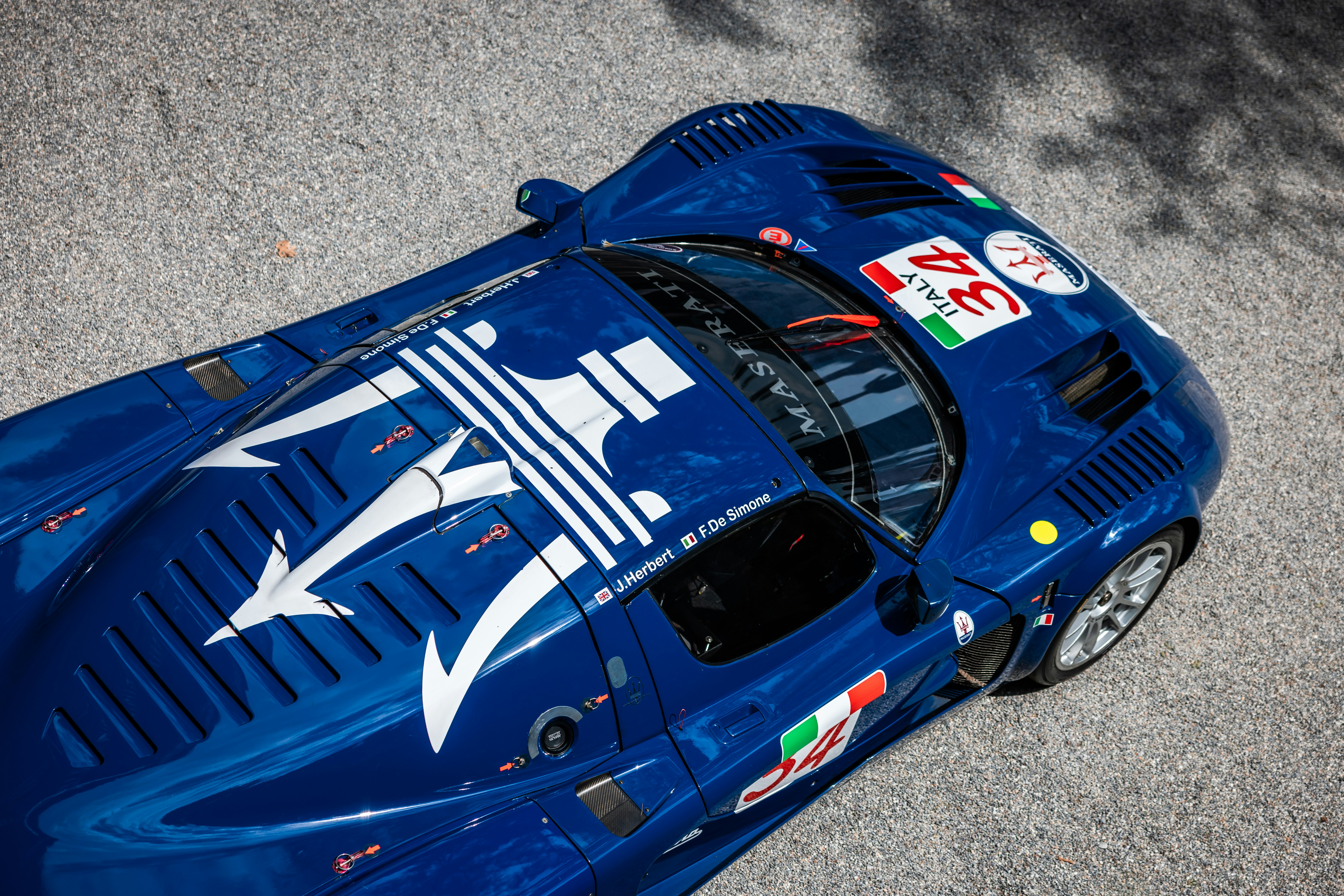 A blue maserati race car is seen from above.