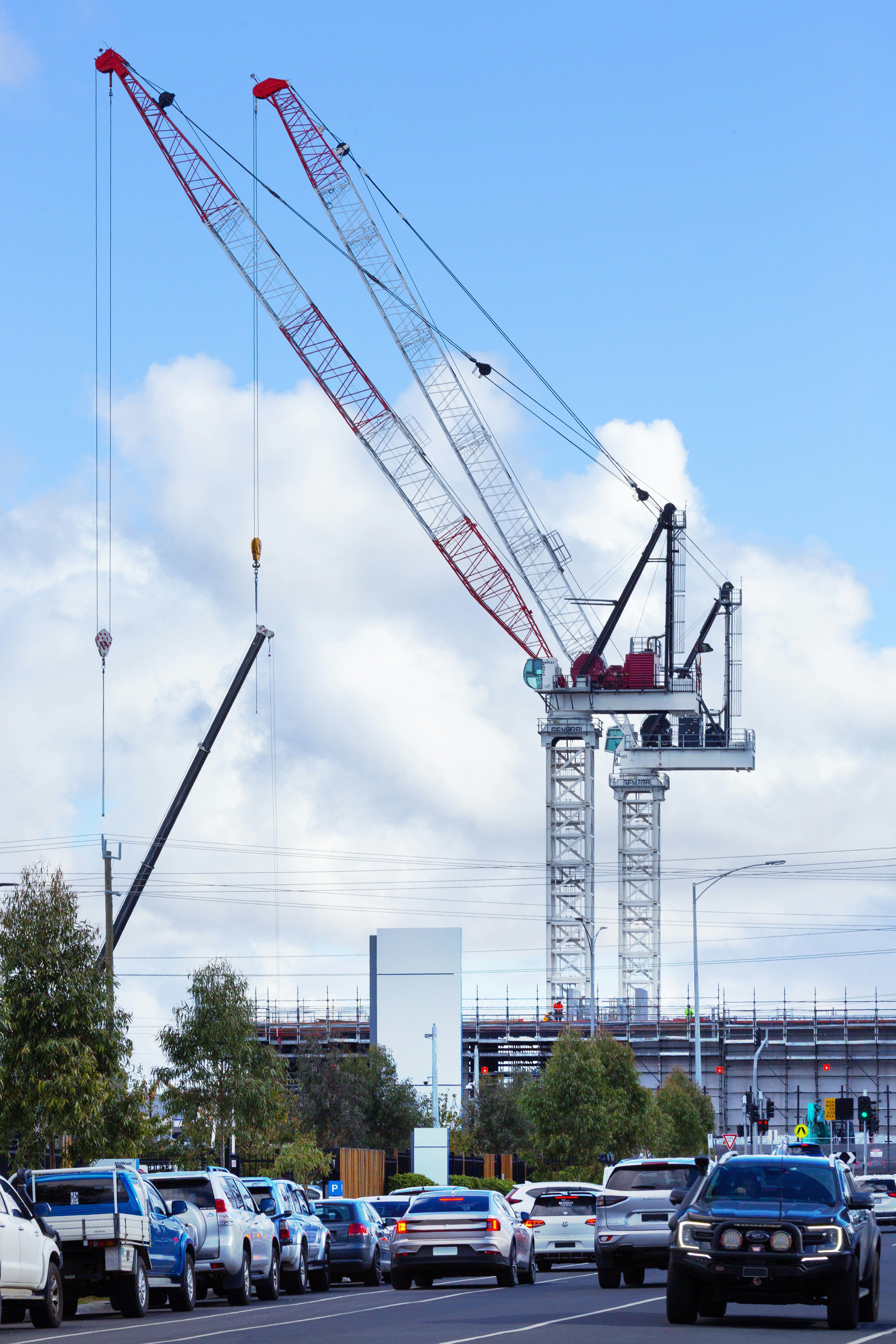 Large crane towers over a road with traffic.