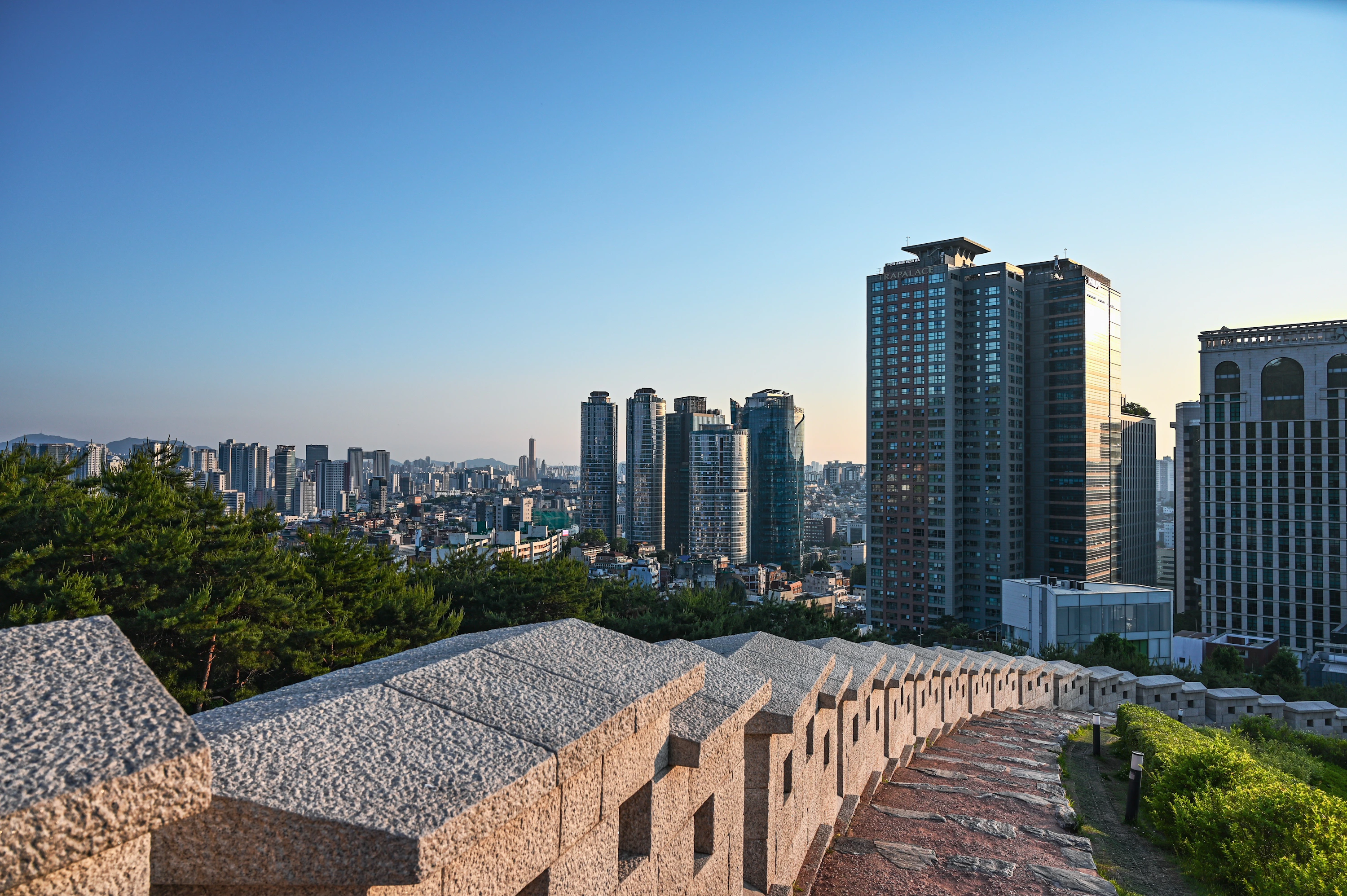 晴空下的首爾城市、綠意與城牆遠景