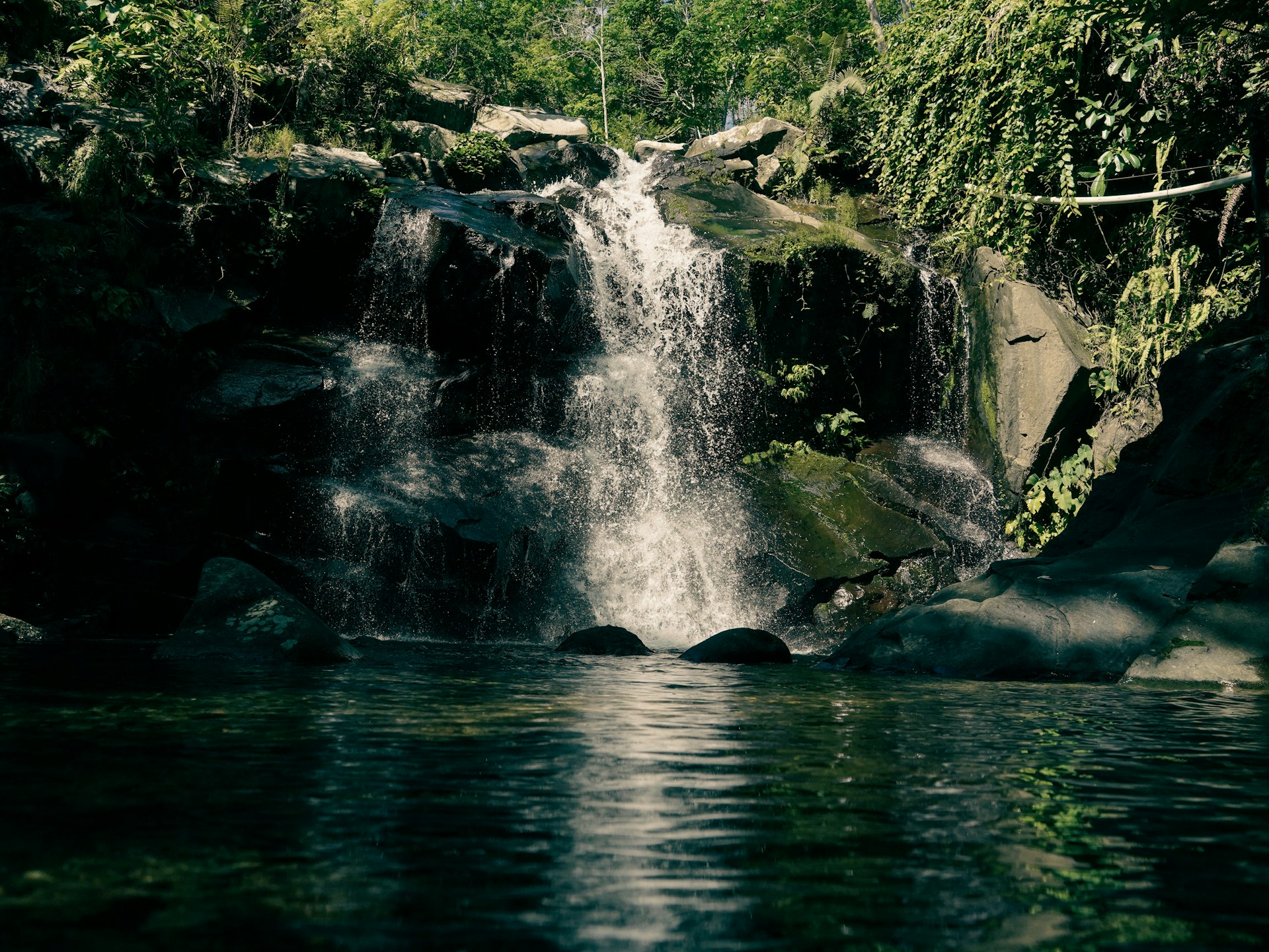 A serene waterfall cascades into a clear pool.