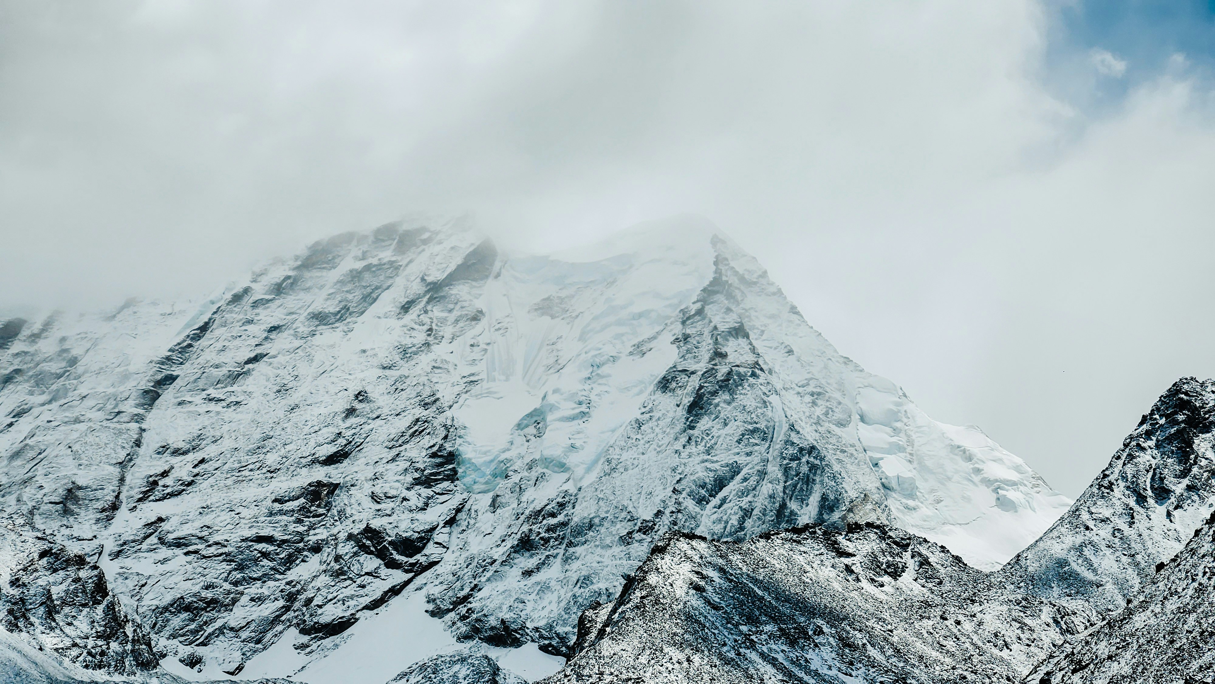 Cime montuose innevate avvolte dalle nuvole.
