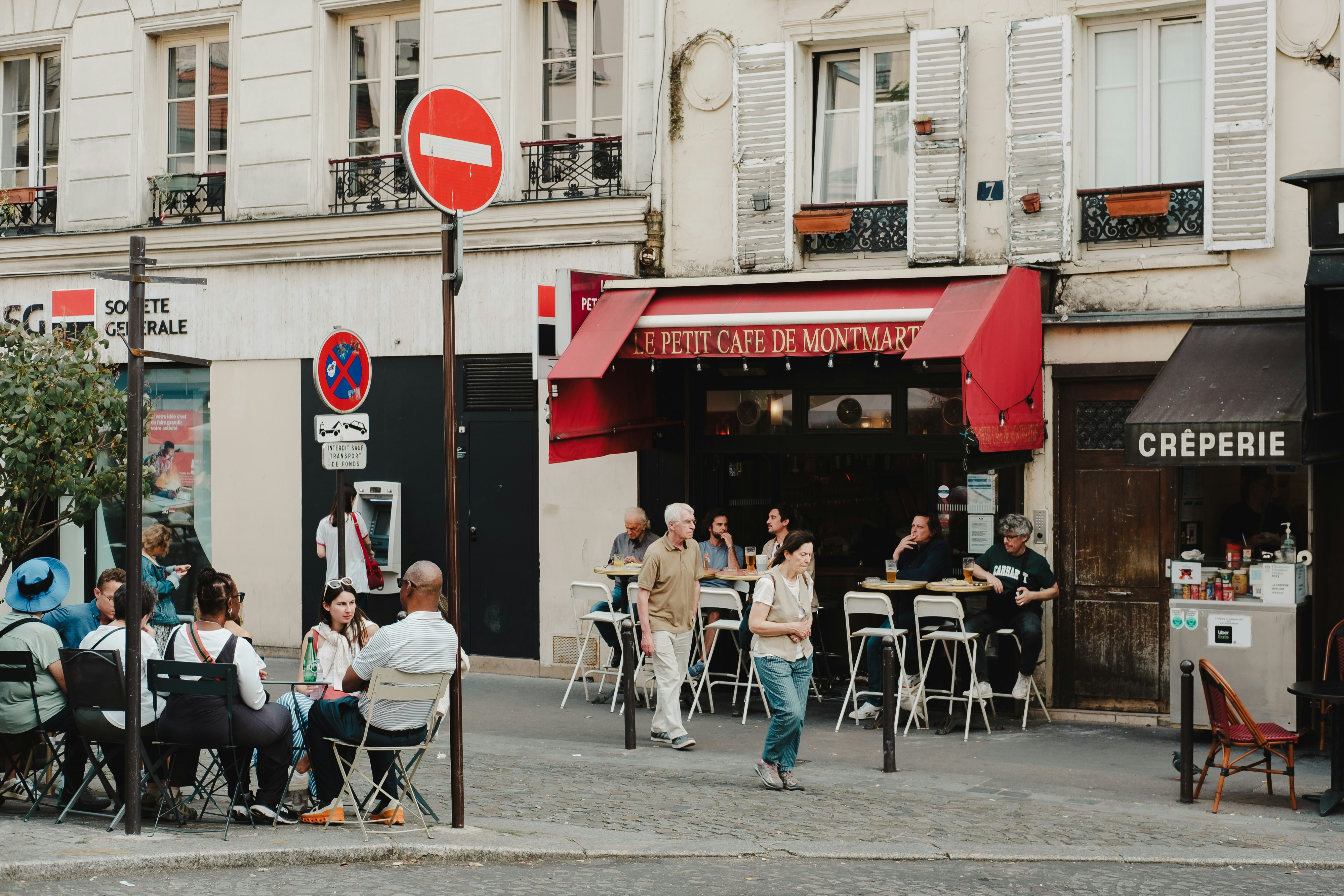 People enjoy a parisian cafe on a sunny day.