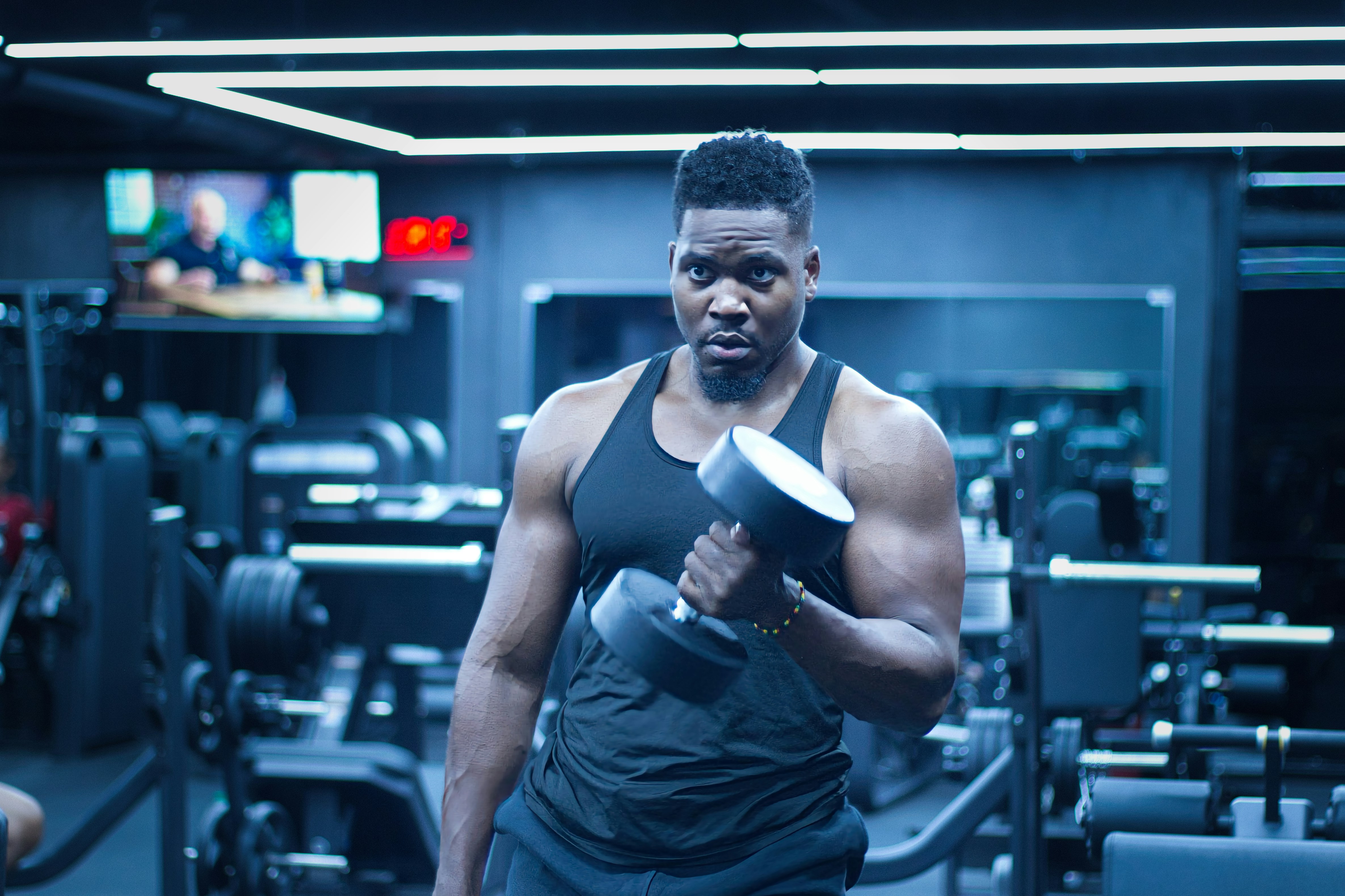 운동 초보자가 반드시 알아야 할 기본 원칙 - Man lifts a dumbbell in a gym.