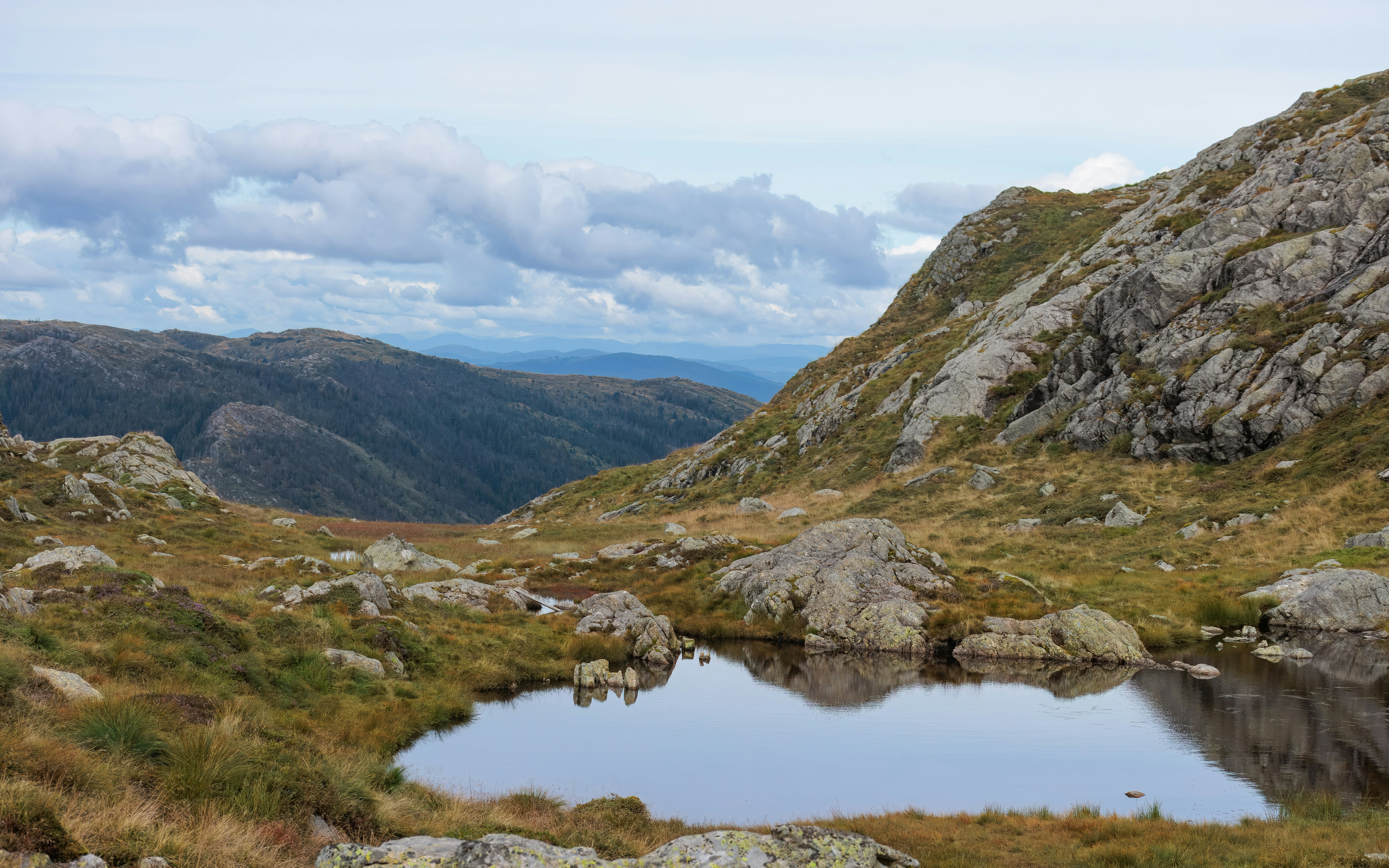 A rocky mountain landscape with a reflective lake.