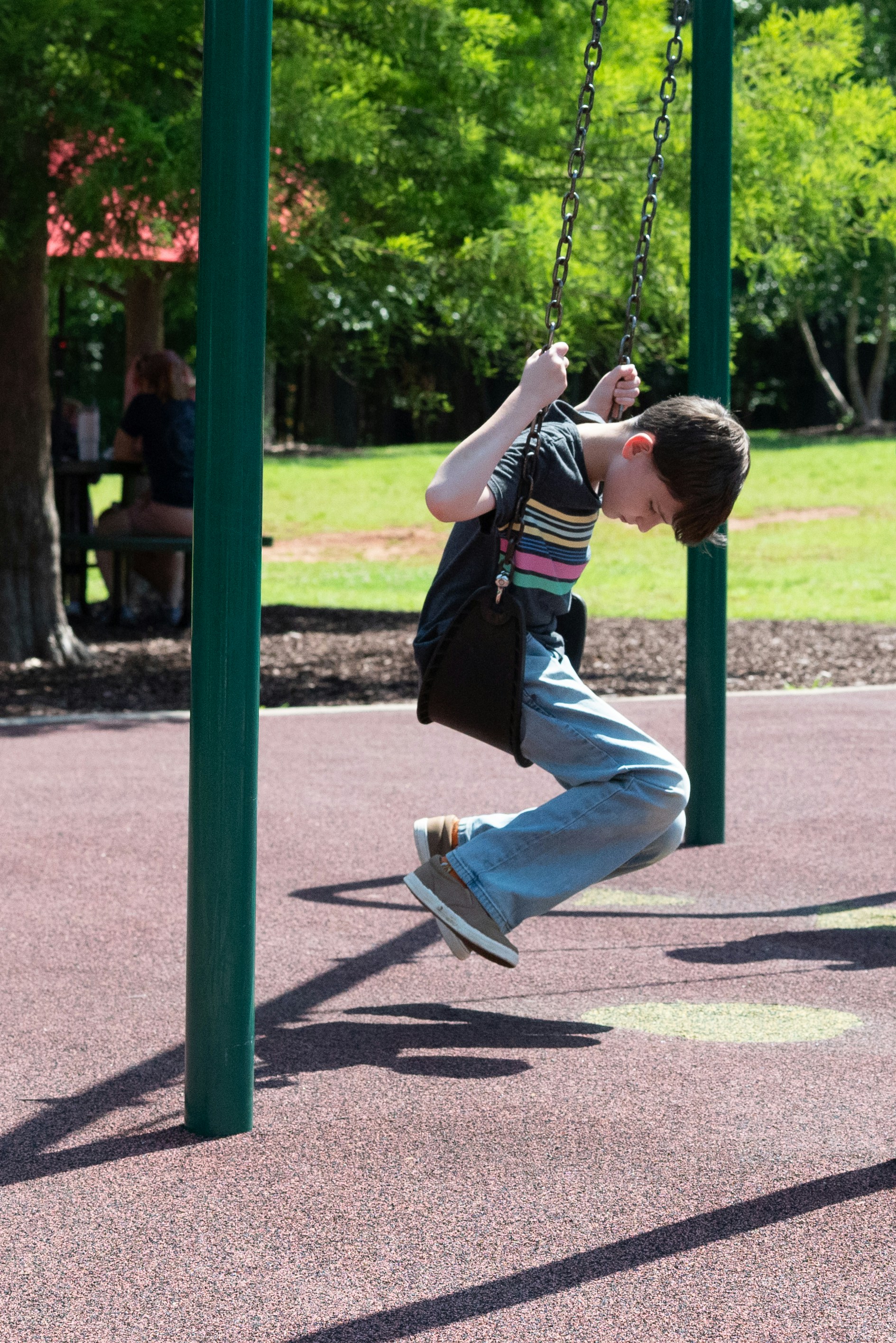A boy swings at the playground.