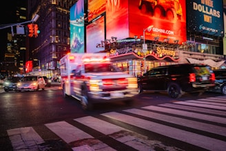 An ambulance races through busy times square.