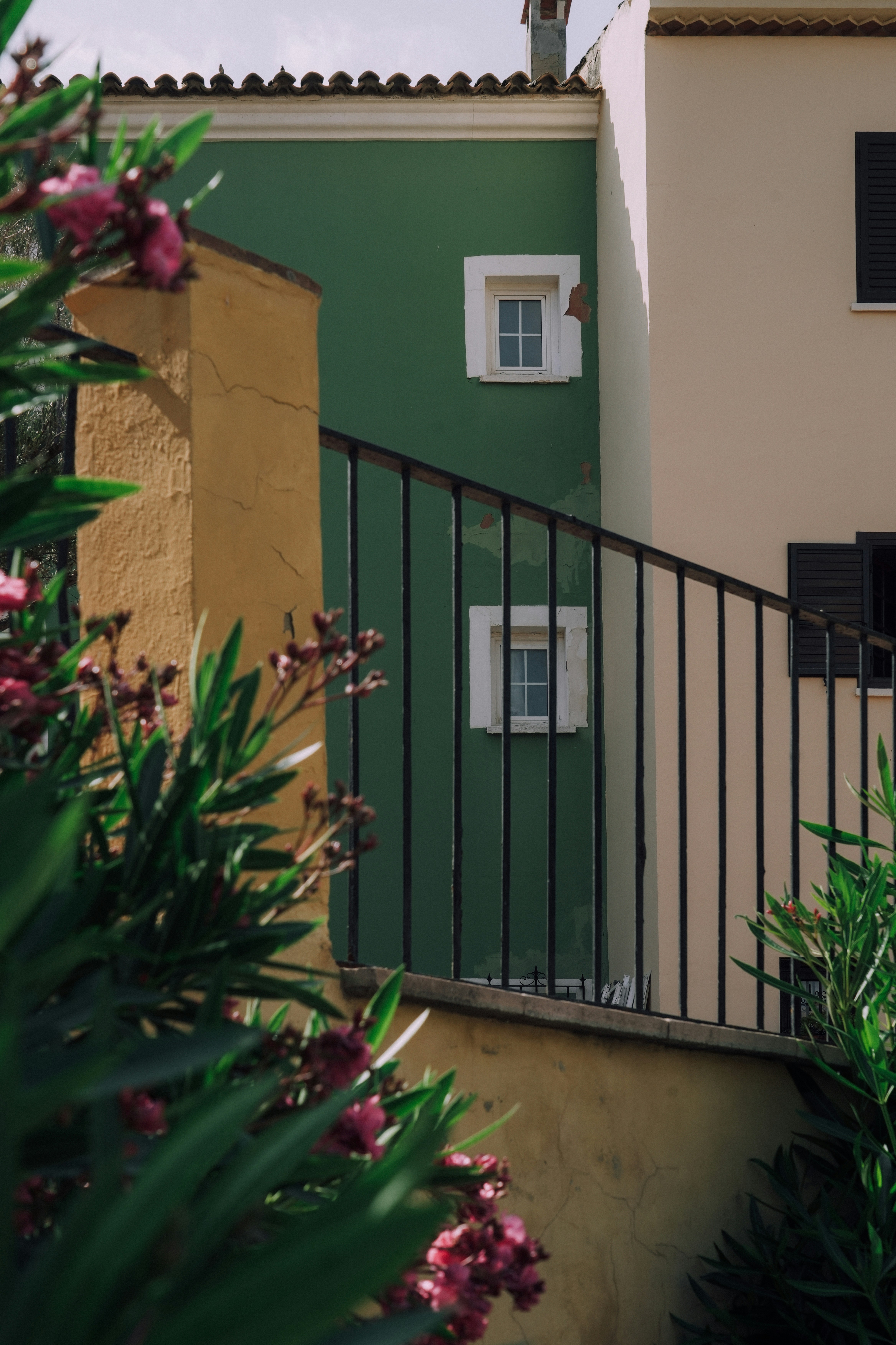 Colorful buildings and a black railing in a scene.