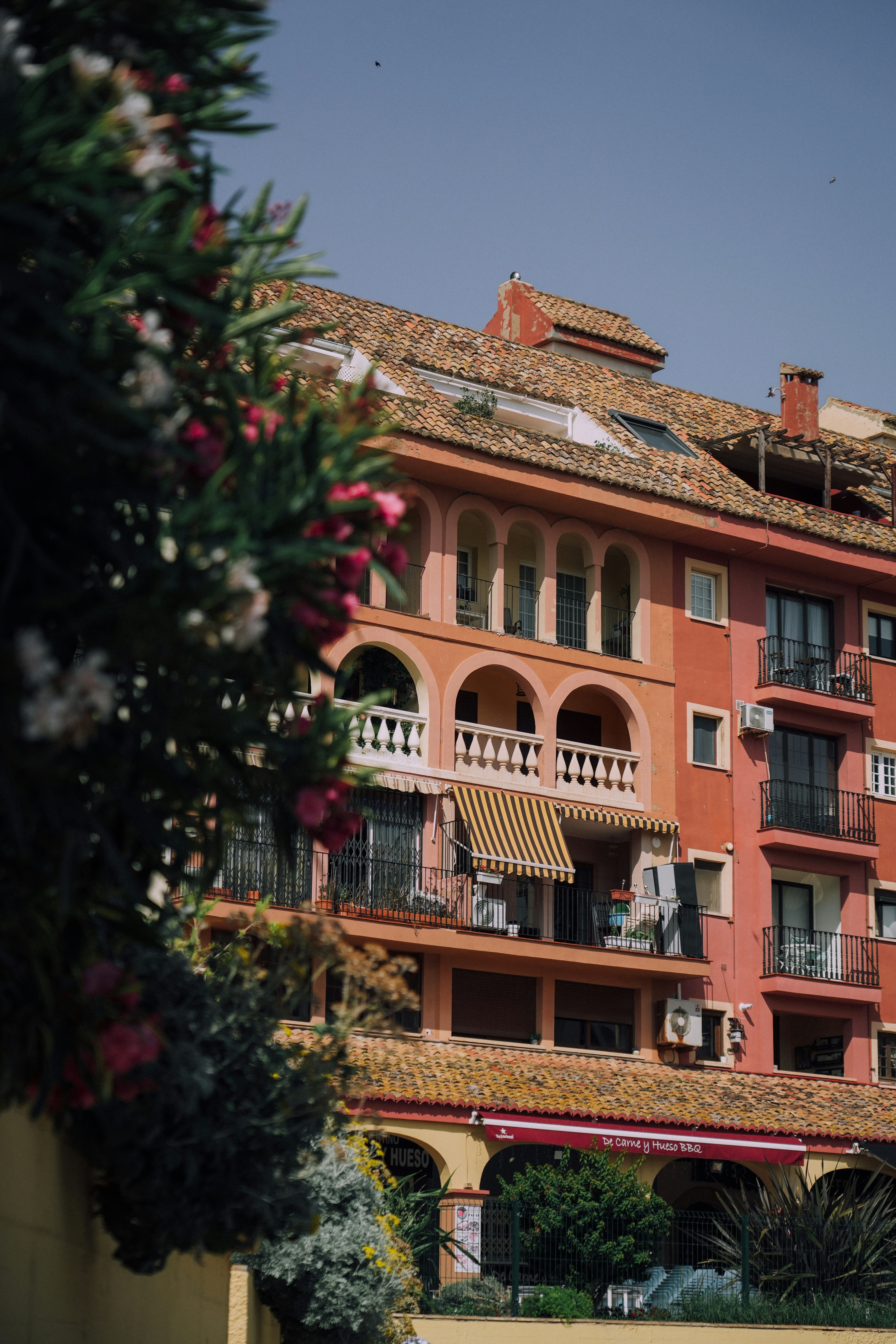 Colorful building with balconies and flowers.