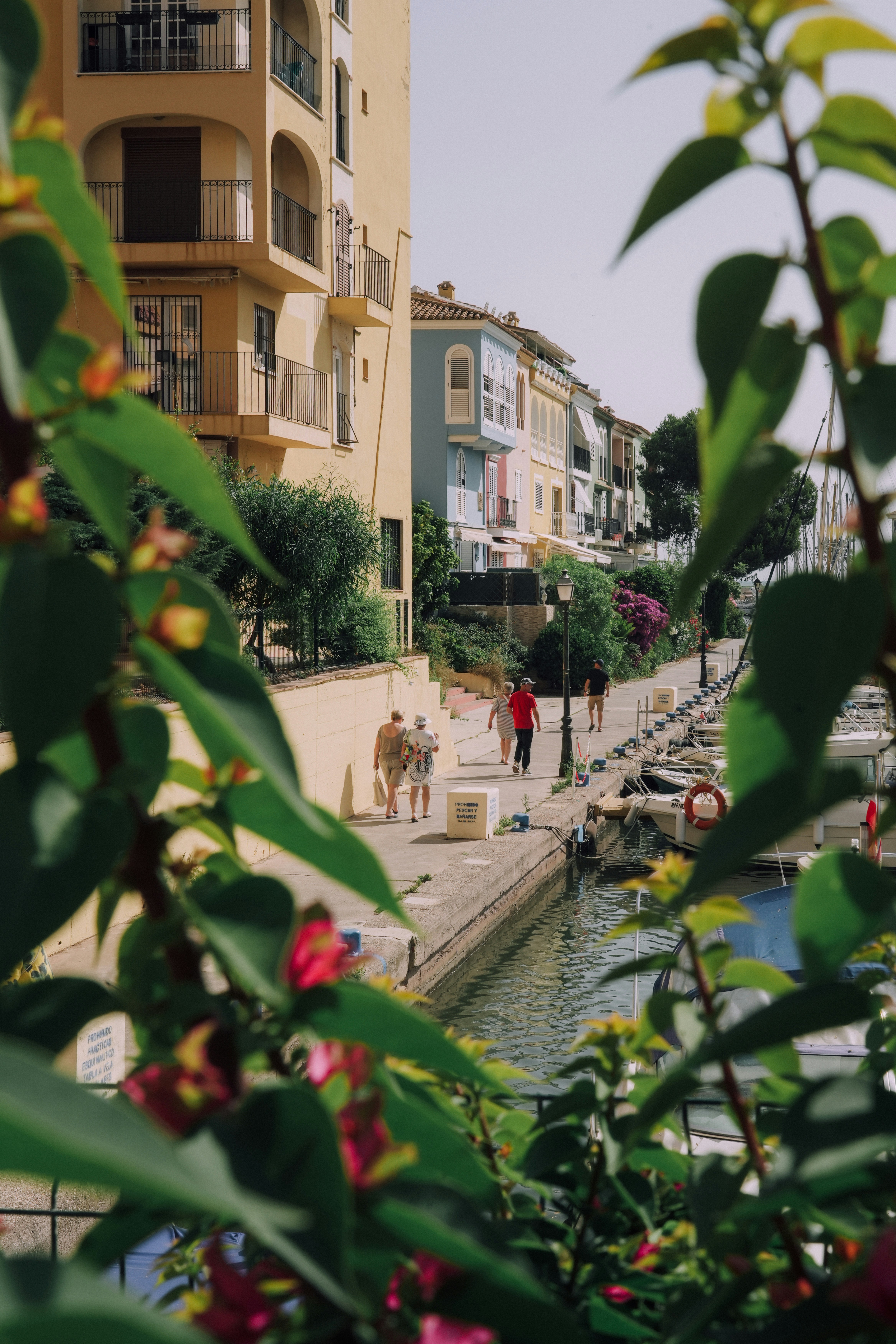 People stroll along a vibrant waterfront street.