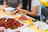People prepare a charcuterie board with fruit.