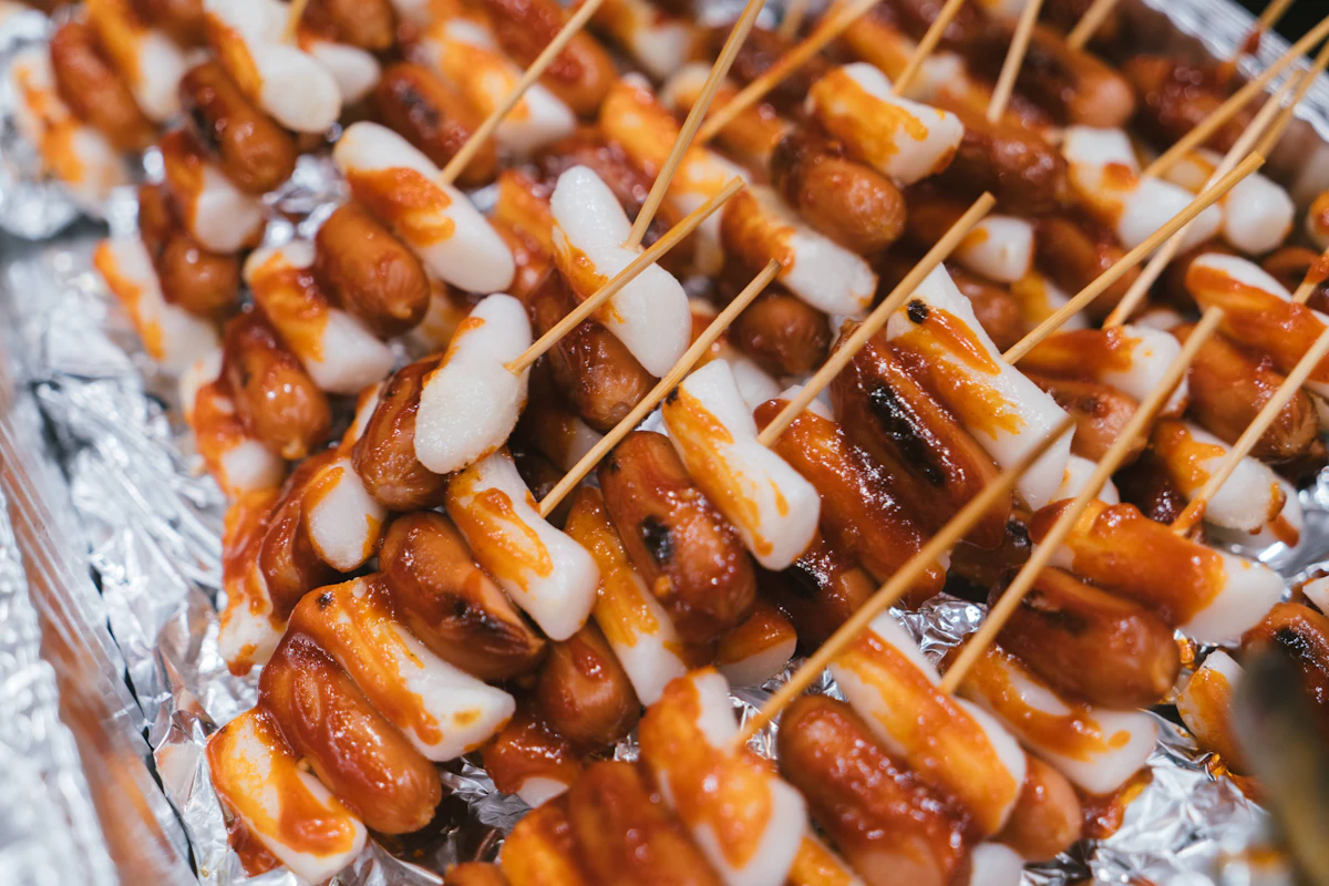 Korean sotteok skewers of sausage and rice cake glazed in red sauce