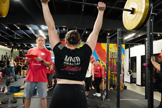 A woman successfully lifts a heavy barbell.