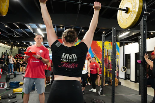 A woman successfully lifts a heavy barbell.