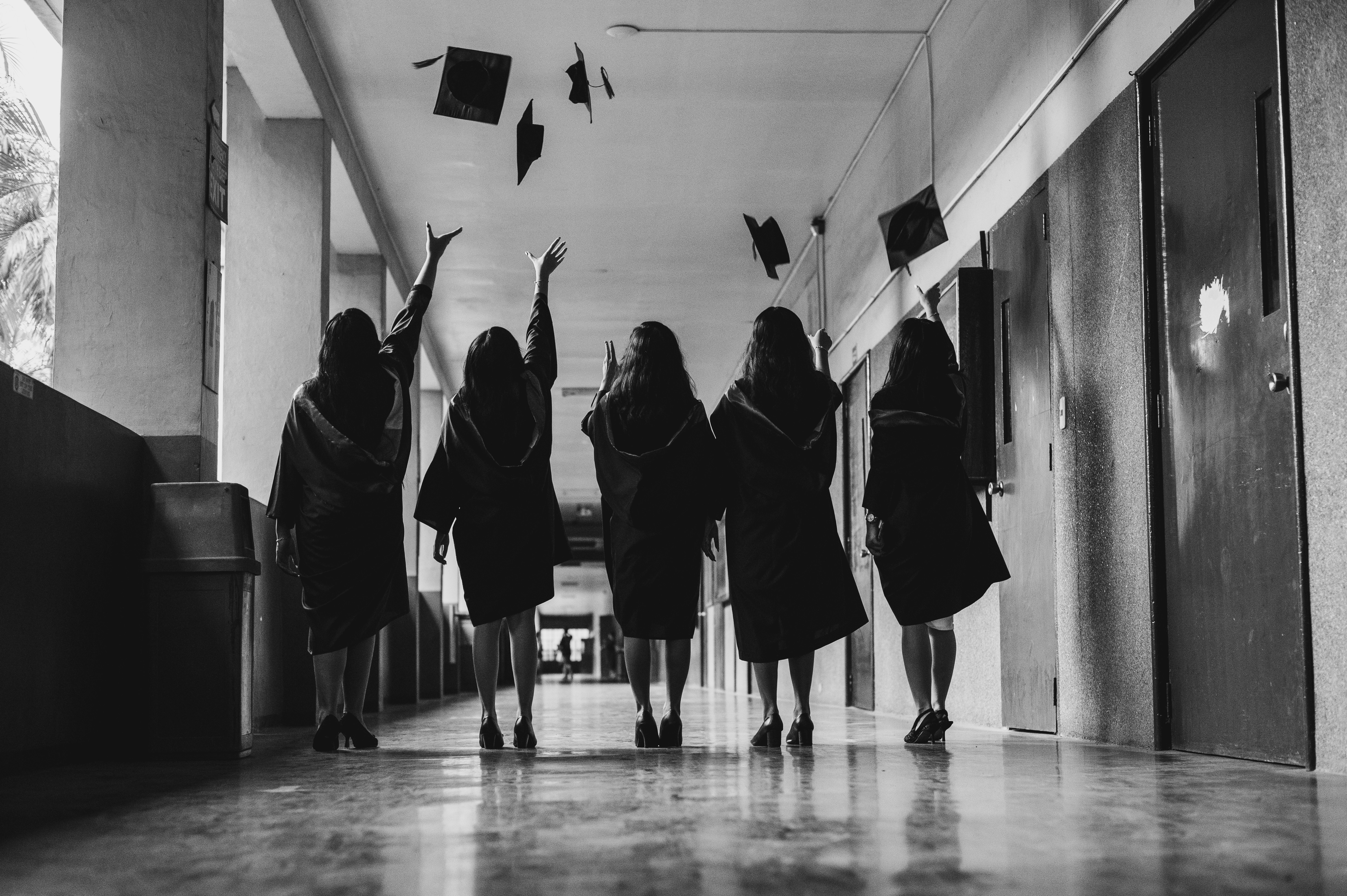 Graduates celebrate their achievement in a hallway.