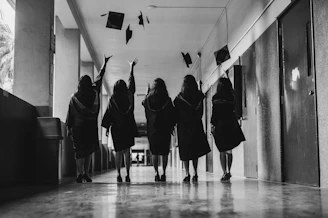 Graduates celebrate their achievement in a hallway.