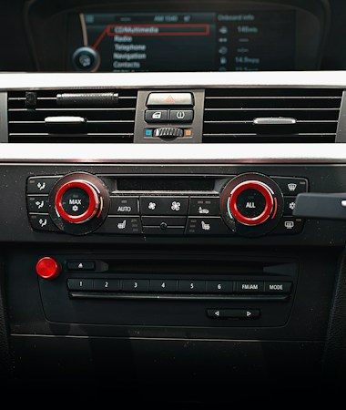 A car dashboard with climate controls and numbered radio preset buttons, a reminder for Las Vegas drivers to save X 107.9 now that Golden Knights games have a new radio home