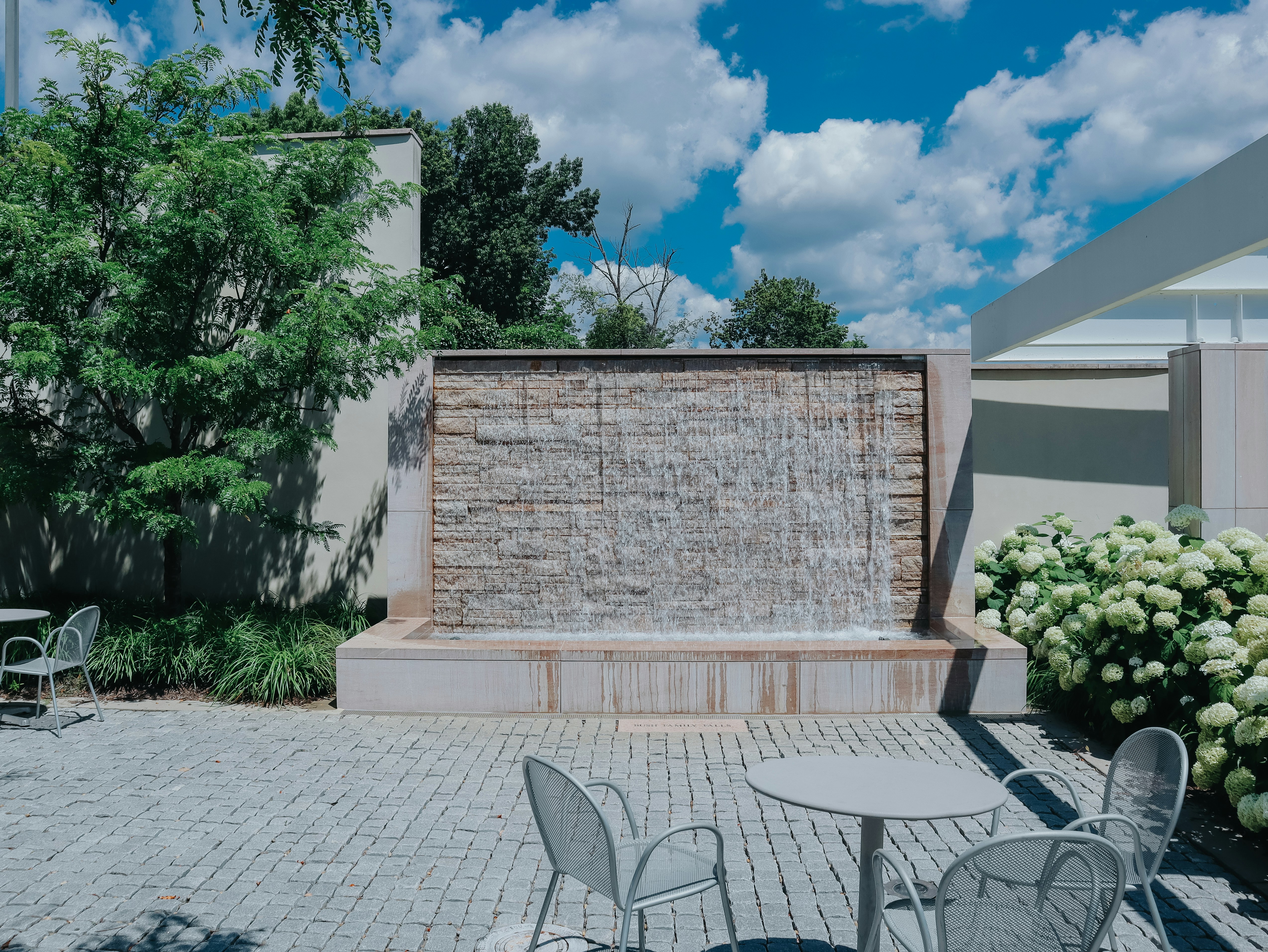 A beautiful waterfall flows in an outdoor patio.