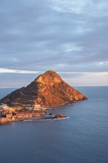 A scenic view of a mountain by the ocean.